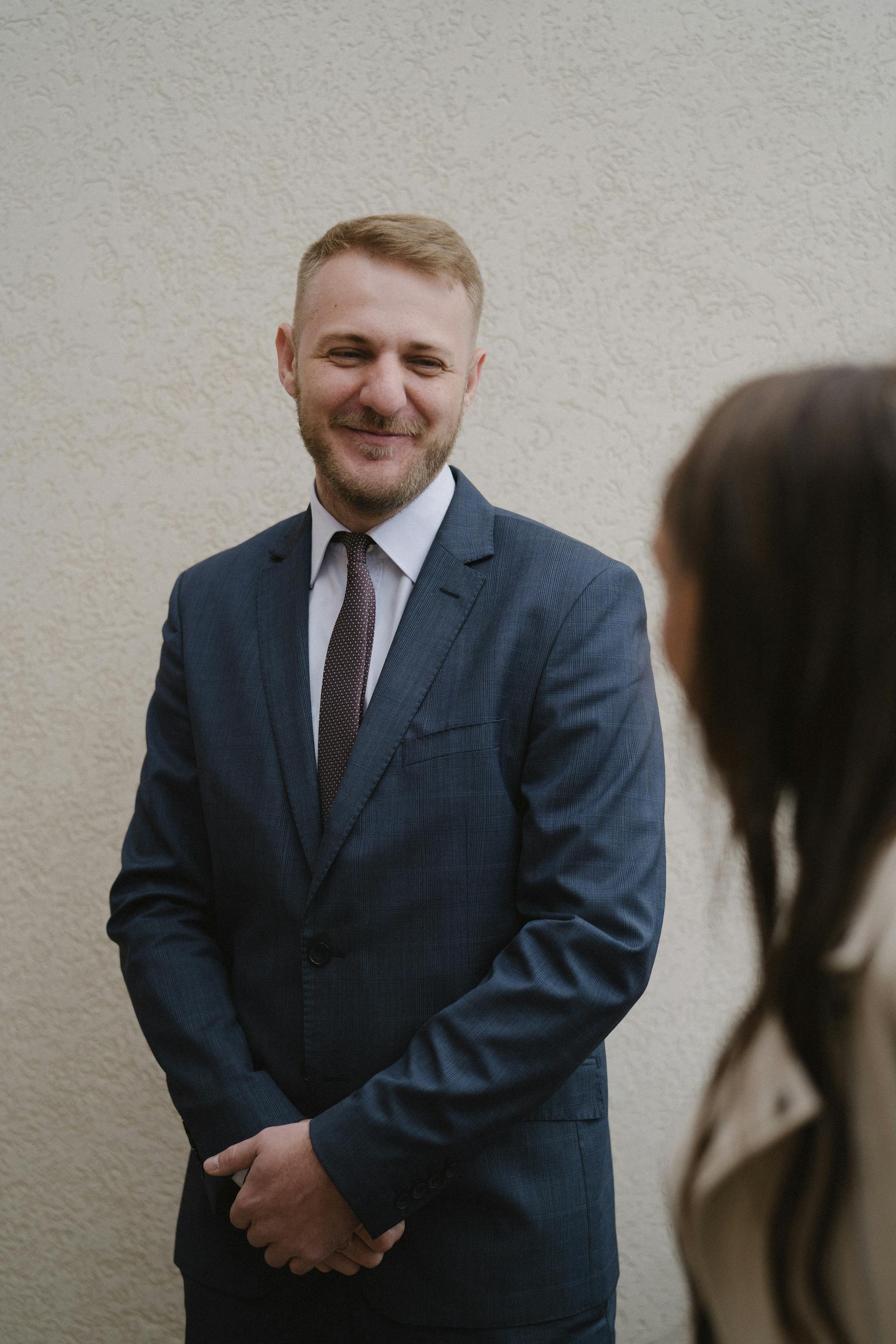 Un homme en costume chic qui sourit à une femme | Source : Pexels