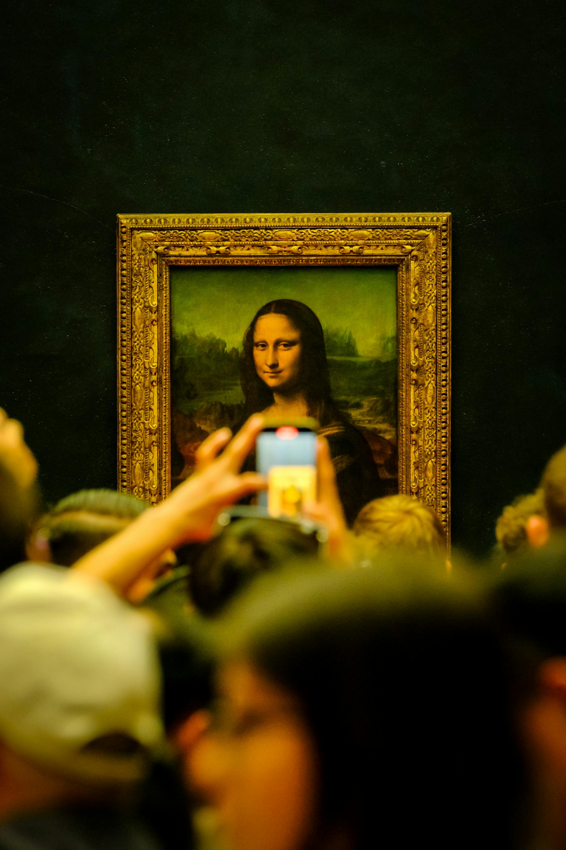 Des gens regardent le tableau de Mona Lisa dans une galerie | Source : Pexels