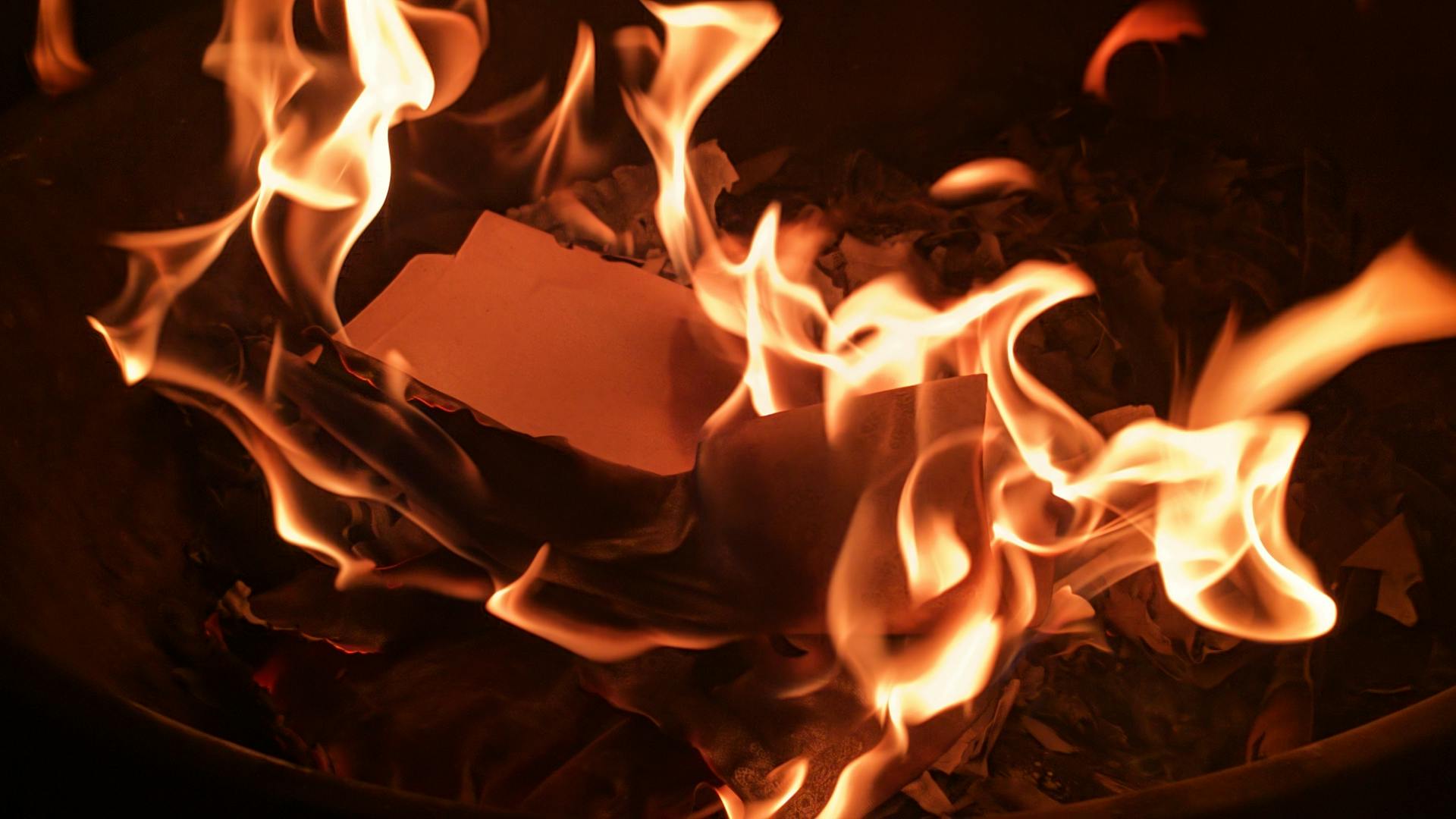 Des flammes engloutissent une pile de papier en feu | Source : Pexels