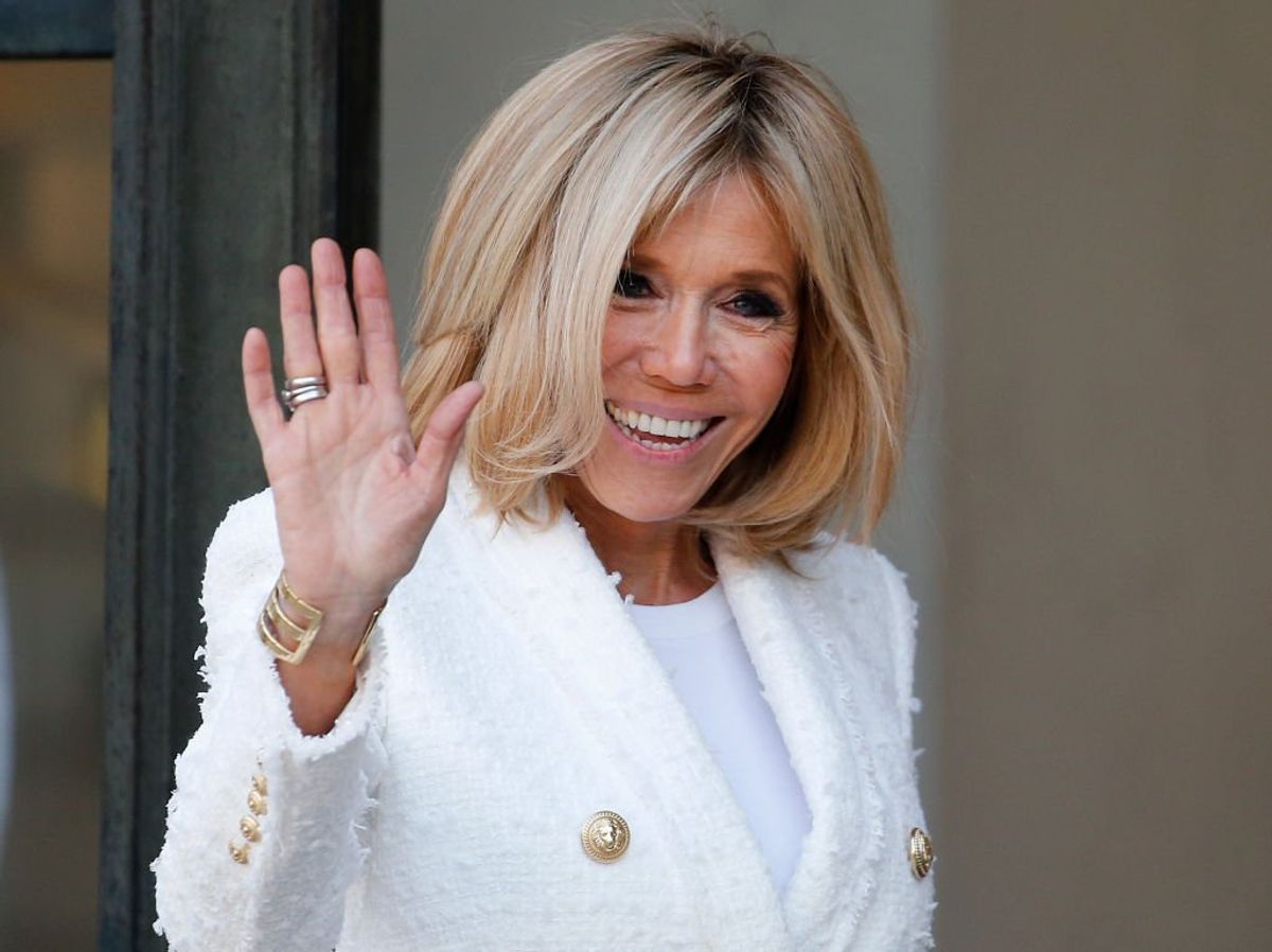 Brigitte Macron salue alors qu'elle accompagne l'épouse du président libérien Clar Weah après leur déjeuner avec le président français Emmanuel Macron et le président libérien George Weah à l'Elysée le 21 février 2018 à Paris. | Photo : Getty Images