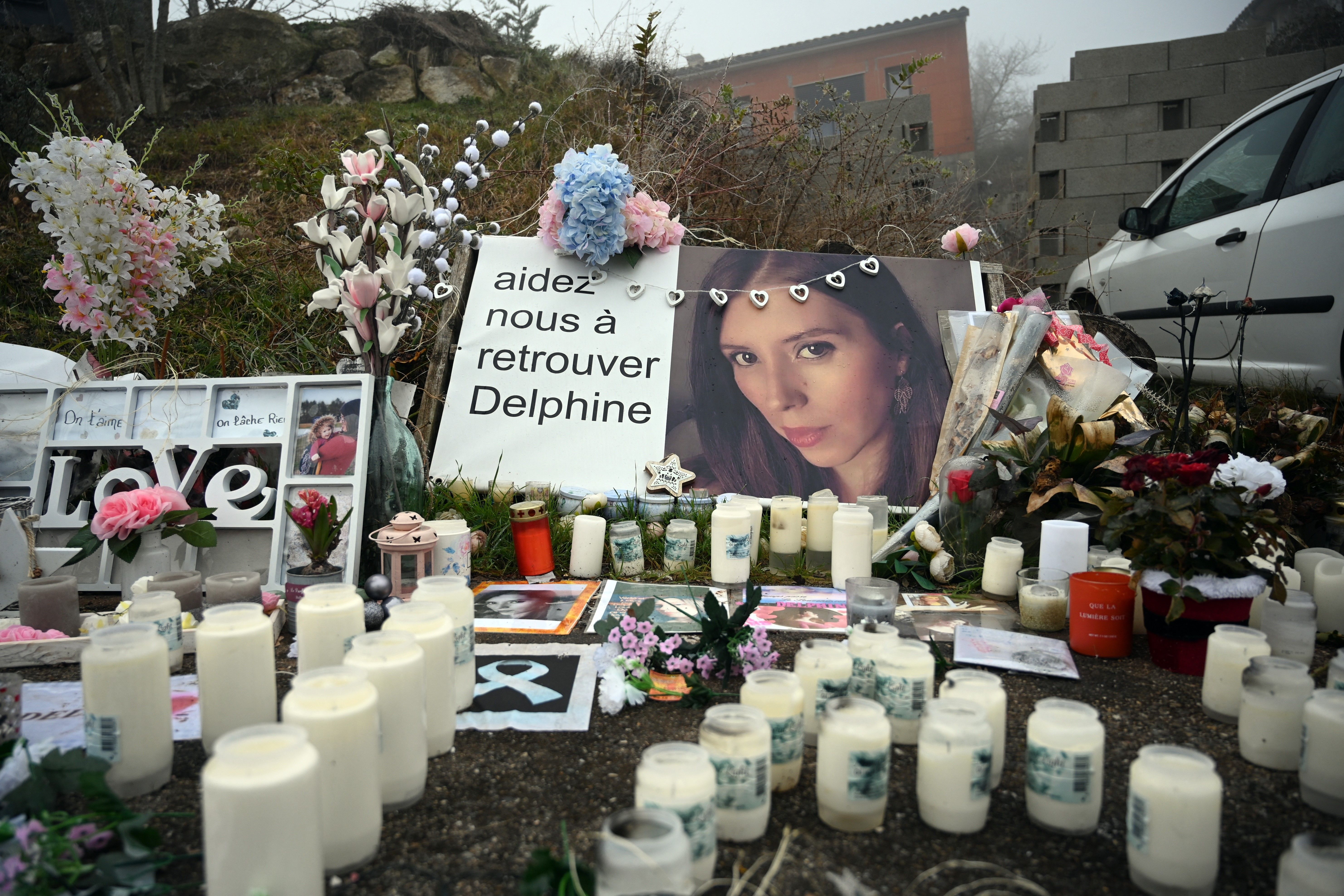 Une photo prise le 17 janvier 2022 montre des bougies et des fleurs devant la maison de Cédric et Delphine Jubillar (portrait) à Cagnac-les-Mines I Source : Getty Images