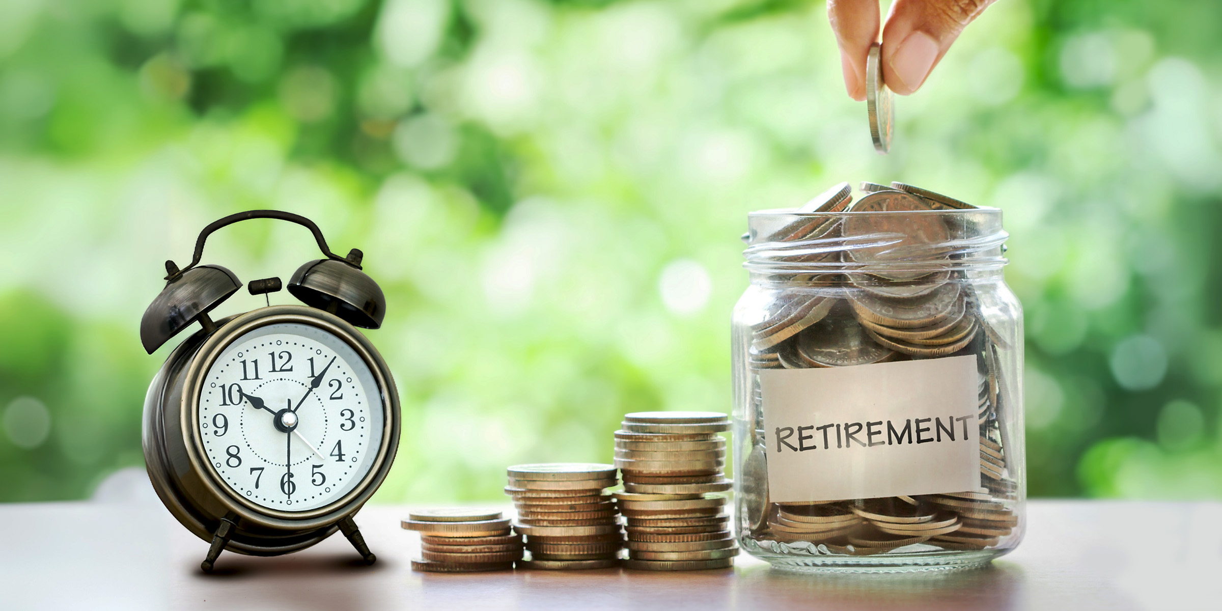 Une personne ajoutant des pièces de monnaie dans un bocal | Source : Shutterstock
