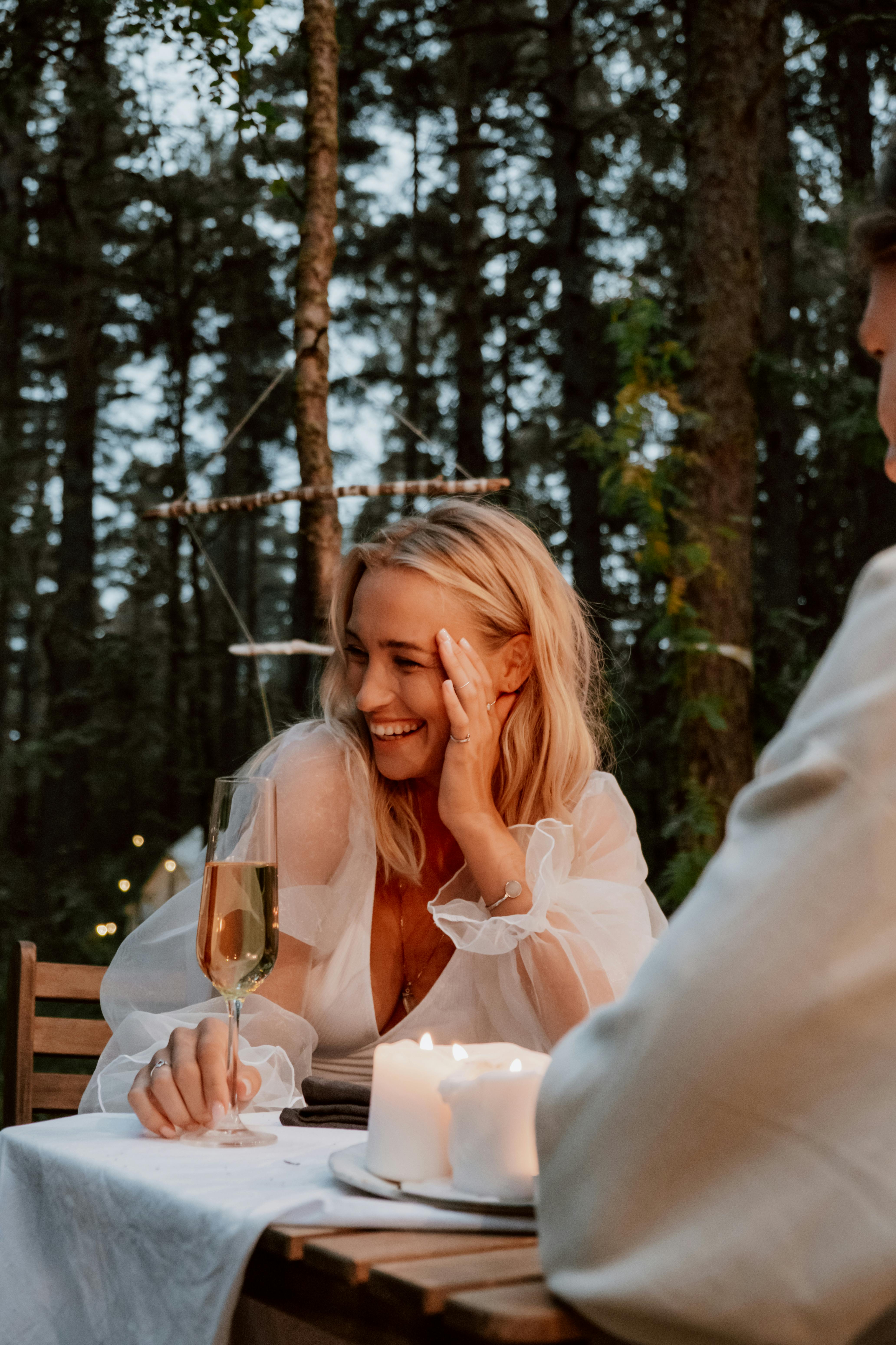 Une femme qui rit pendant un dîner en tête à tête | Source : Pexels