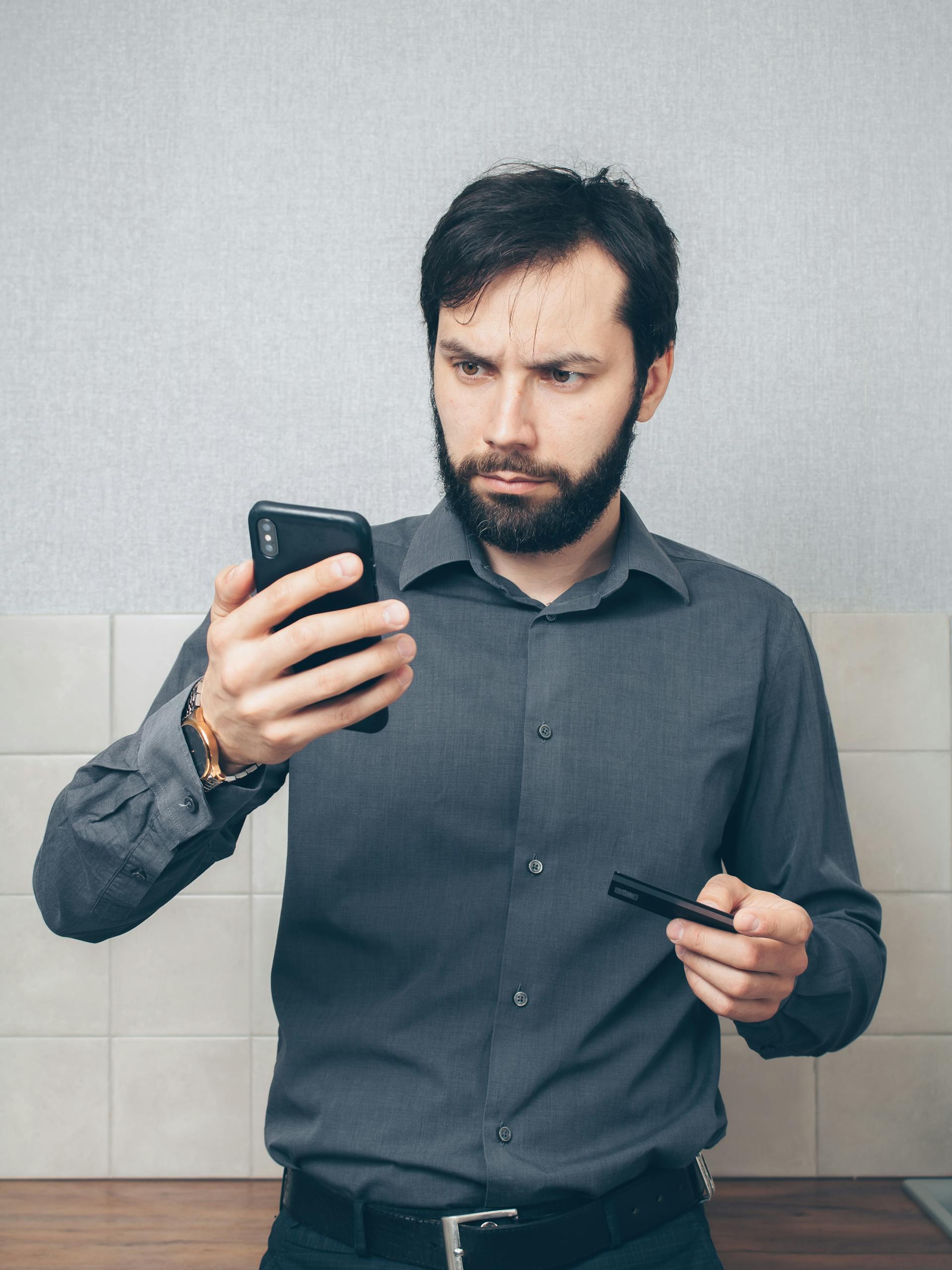 Un homme qui regarde son smartphone | Source : Pexels