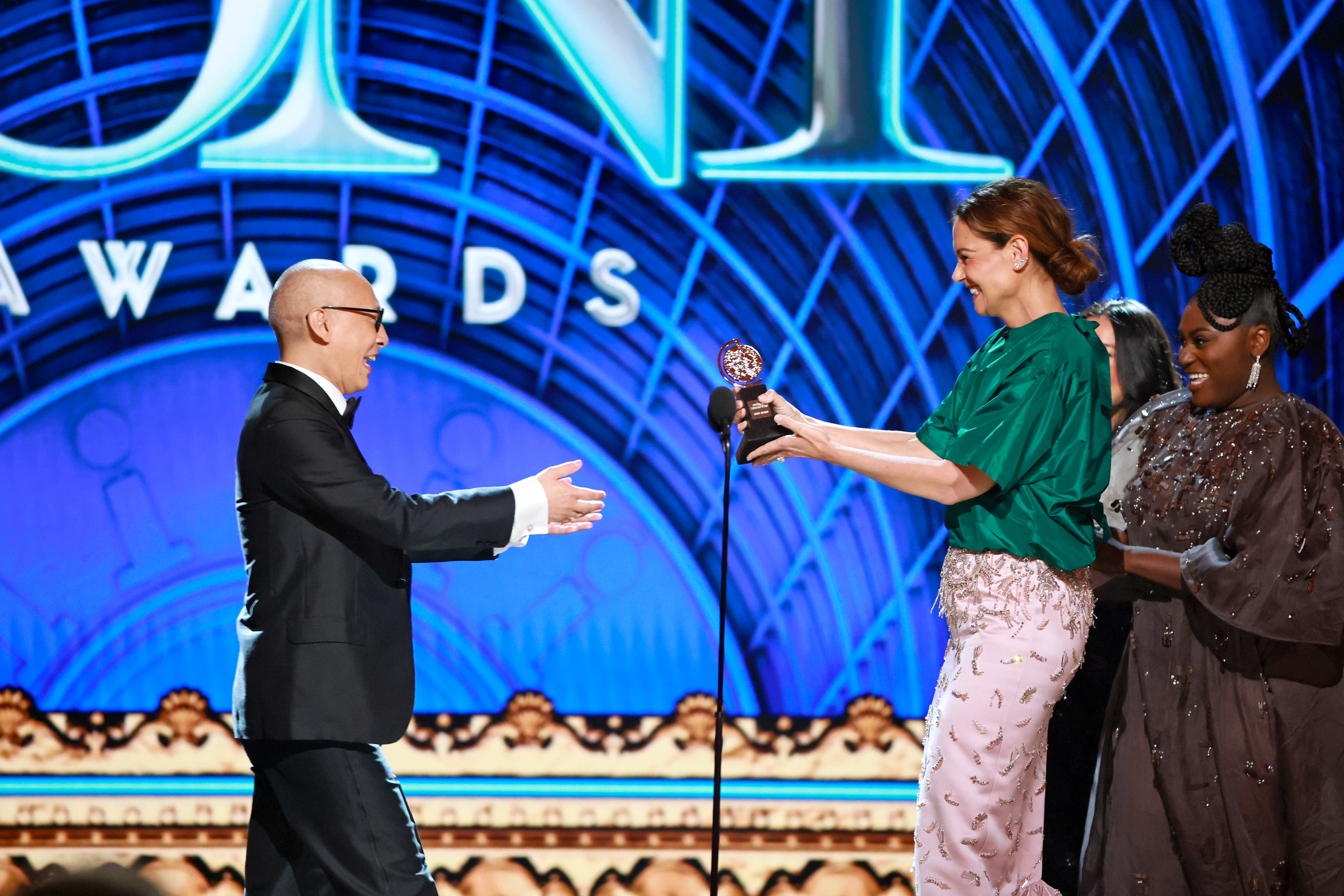 Francis Jue reçoit son Tony Award du meilleur acteur dans une pièce de théâtre des mains de Katie Holmes et Danielle Brooks. Holmes rayonne en remettant le trophée, marquant ainsi l'un des moments les plus sincères de la cérémonie.