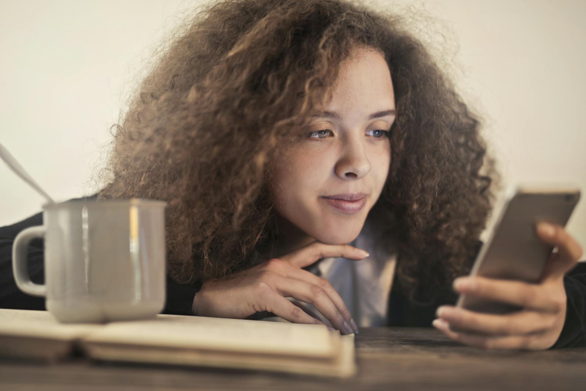 Une femme fixant l'écran d'un téléphone portable | Source : Pexels