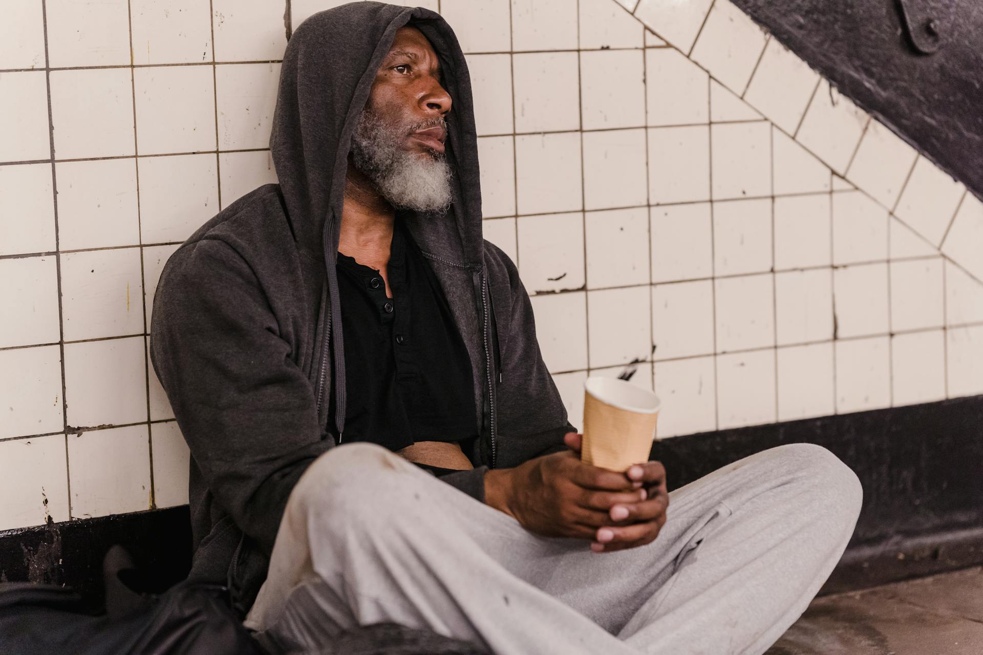 Un sans-abri tenant un gobelet en papier | Source : Pexels