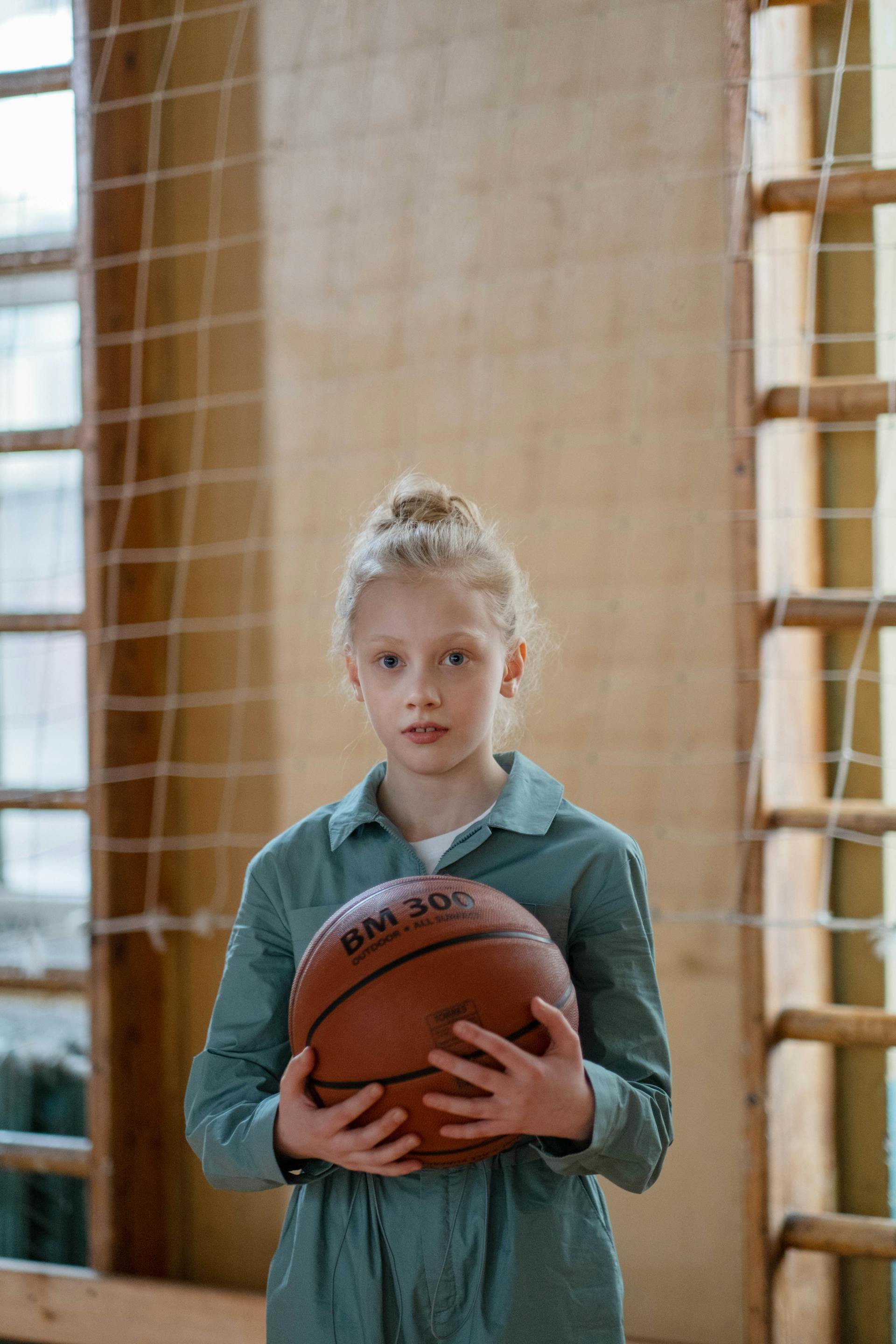Une adolescente à l'air nerveux tenant un ballon de basket | Source : Pexels