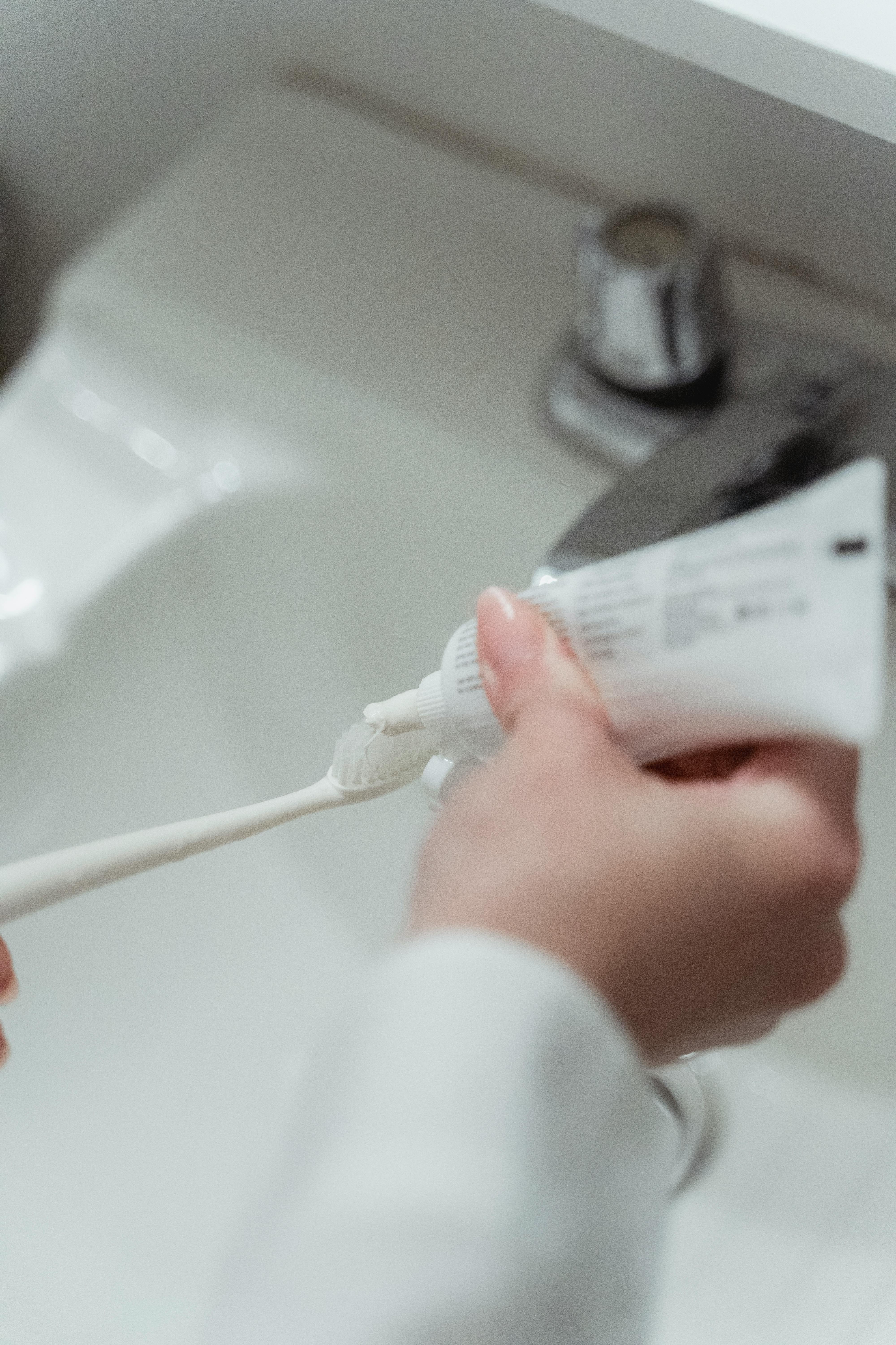 Une personne tenant une brosse à dents et un tube de dentifrice | Source : Pexels