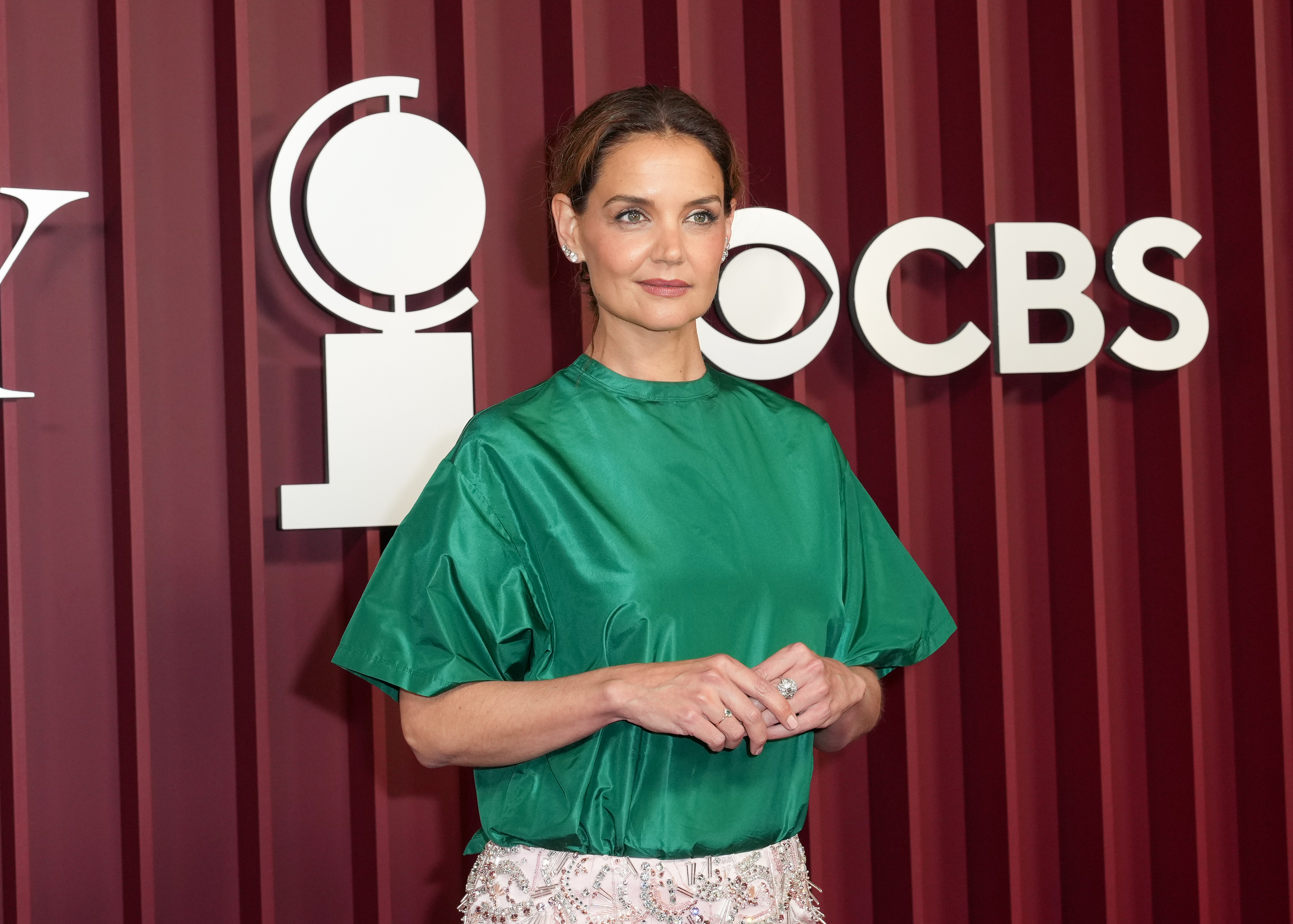 Portant une combinaison de couleurs audacieuse, Katie Holmes semble équilibrée dans un satin vert et un maquillage aux tons doux, debout devant les logos CBS et Tony alors qu'elle arrive pour faire une présentation lors de la plus grande soirée de Broadway à New York.