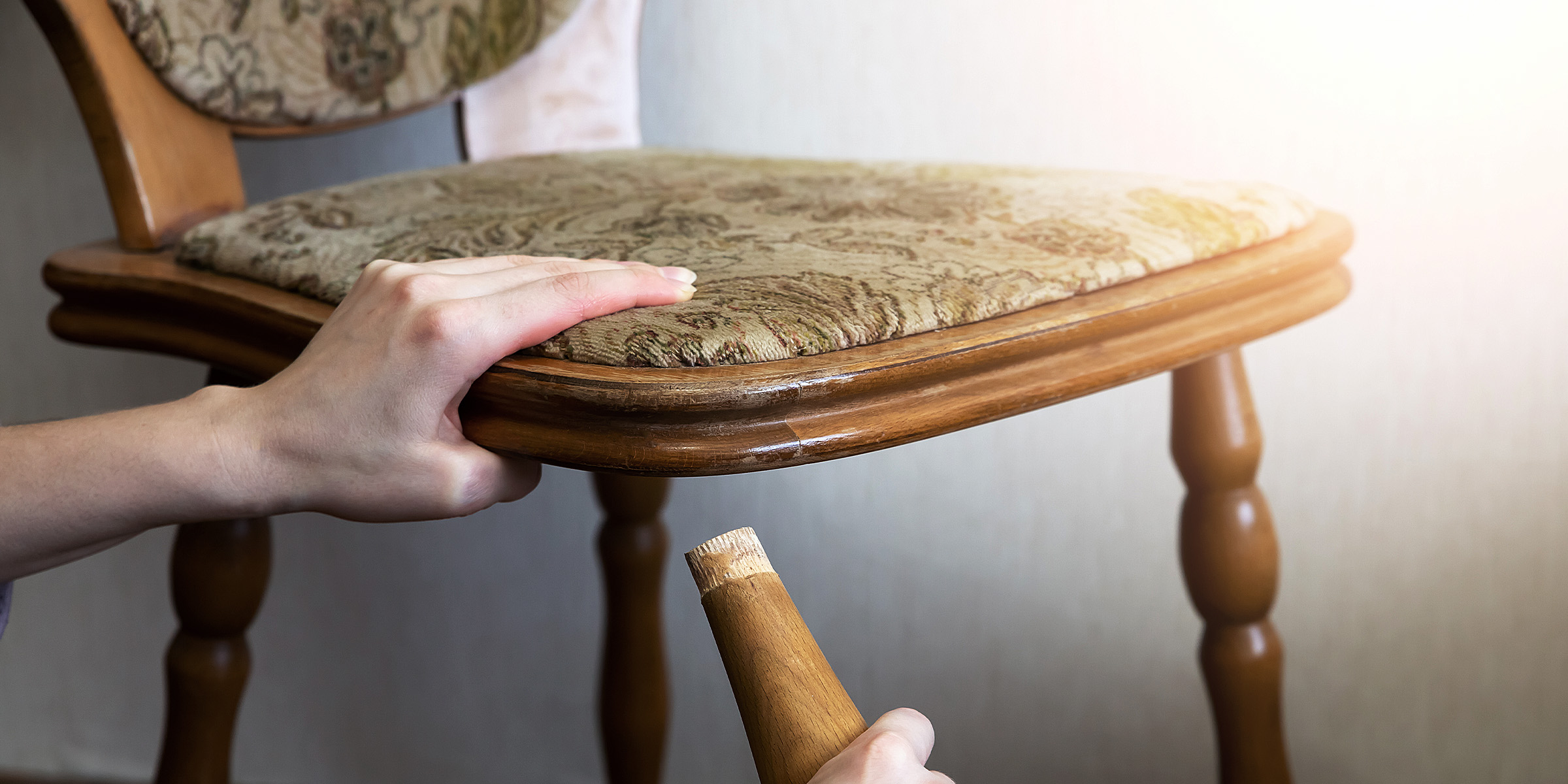 Une femme tenant le pied d'une chaise cassée | Source : Shutterstock