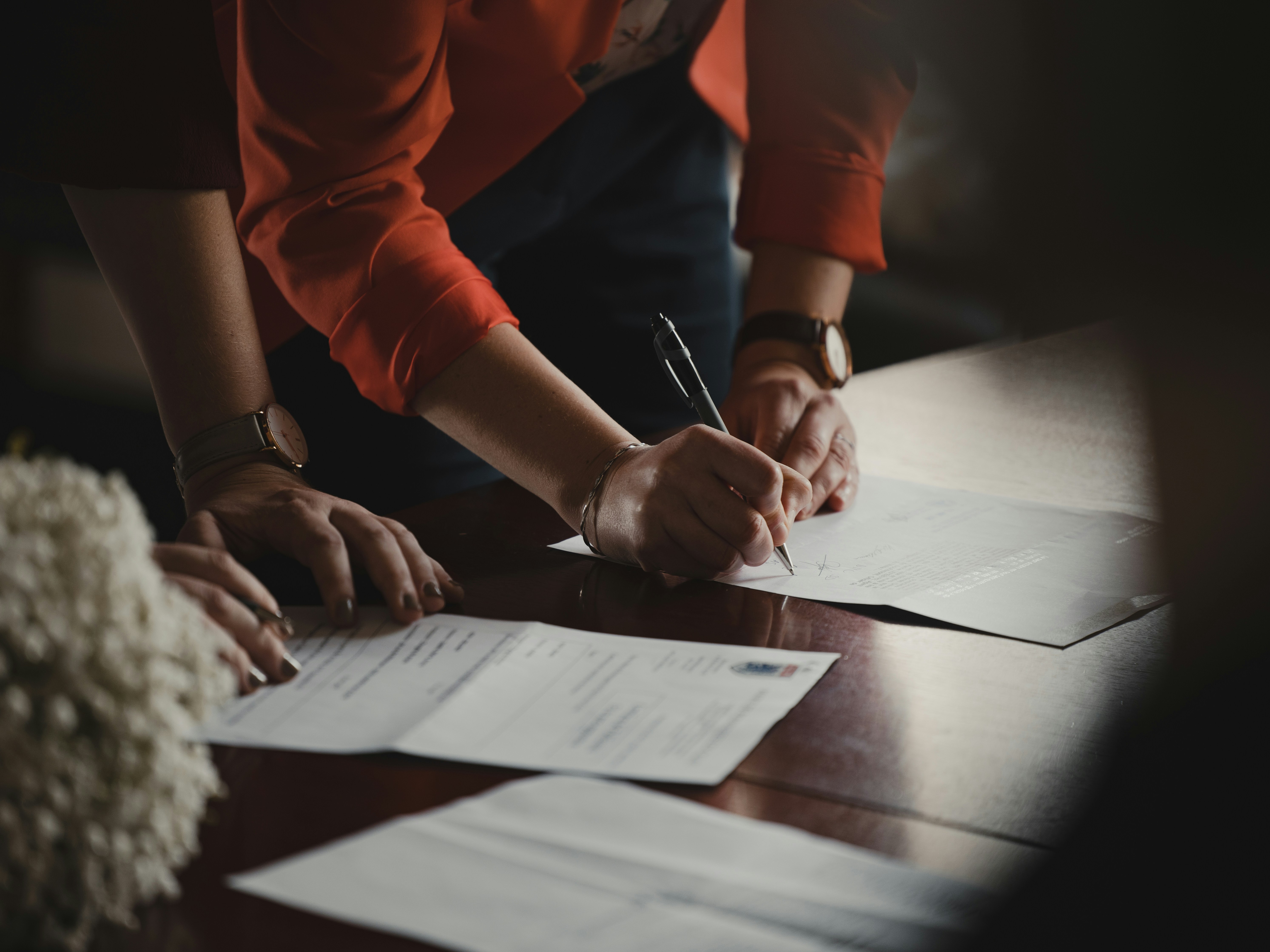 Des personnes signent des documents sur la table | Source : Unsplash
