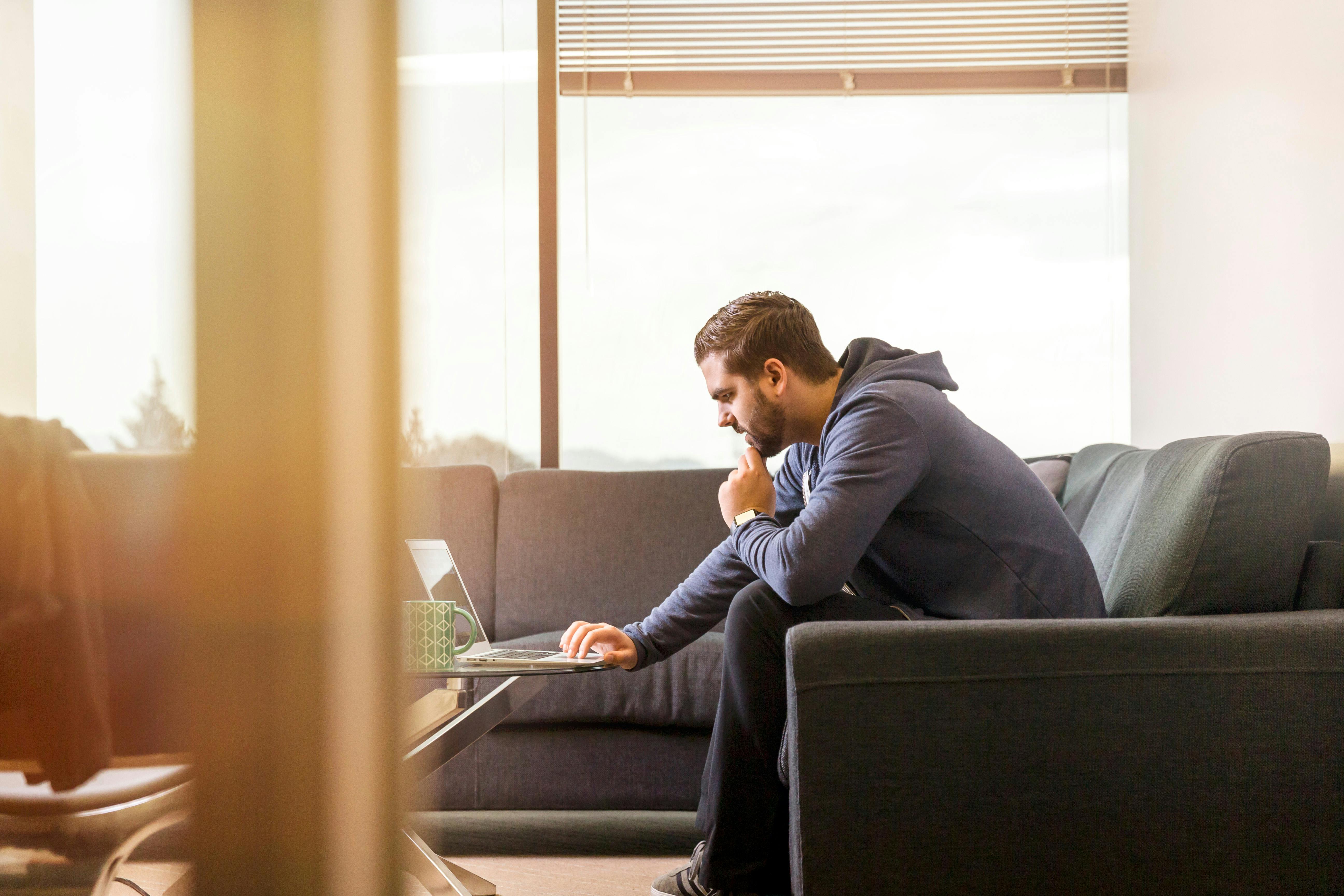 Un homme assis sur un canapé | Source : Pexels