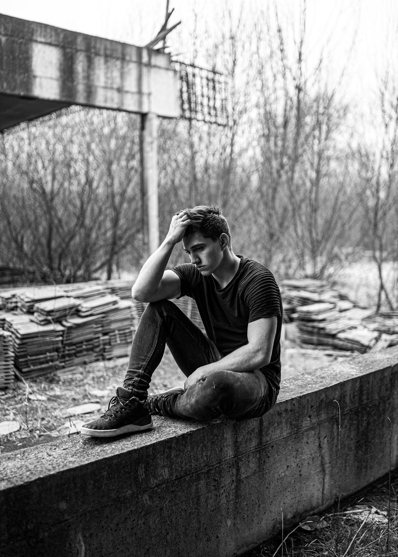 Photo en niveaux de gris d'un jeune homme triste | Source : Pexels