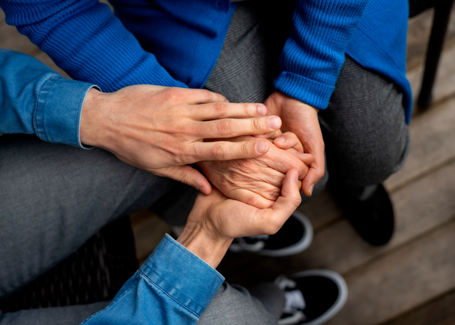 Un jeune homme tenant la main d'une personne plus âgée | Source : Freepik