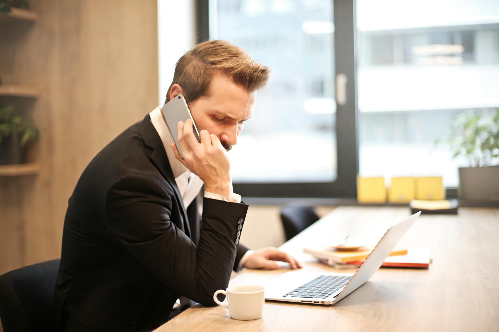 Un homme qui parle au téléphone au travail | Source : Pexels