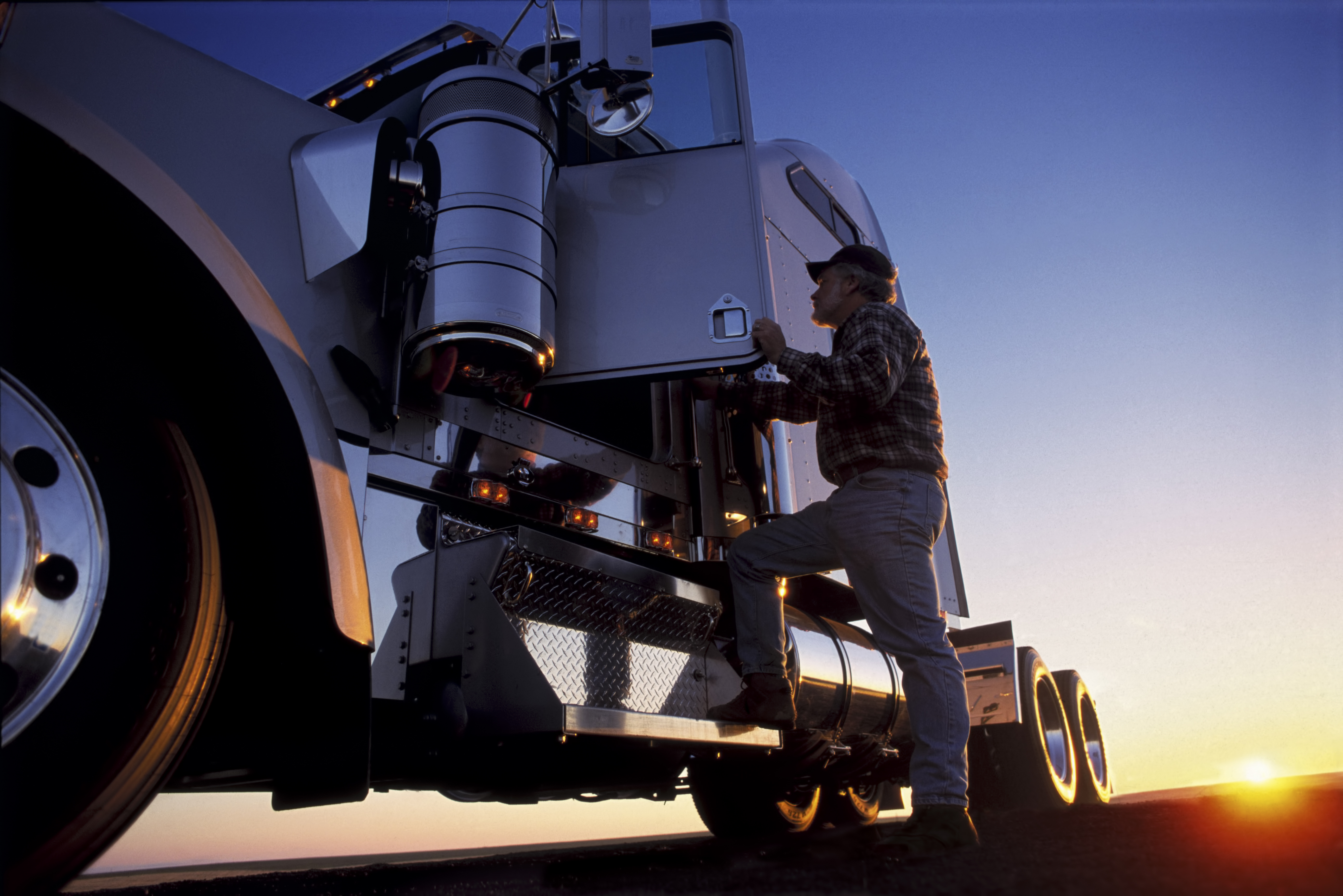 Un homme qui monte dans la cabine de son camion. | Source : Getty Images