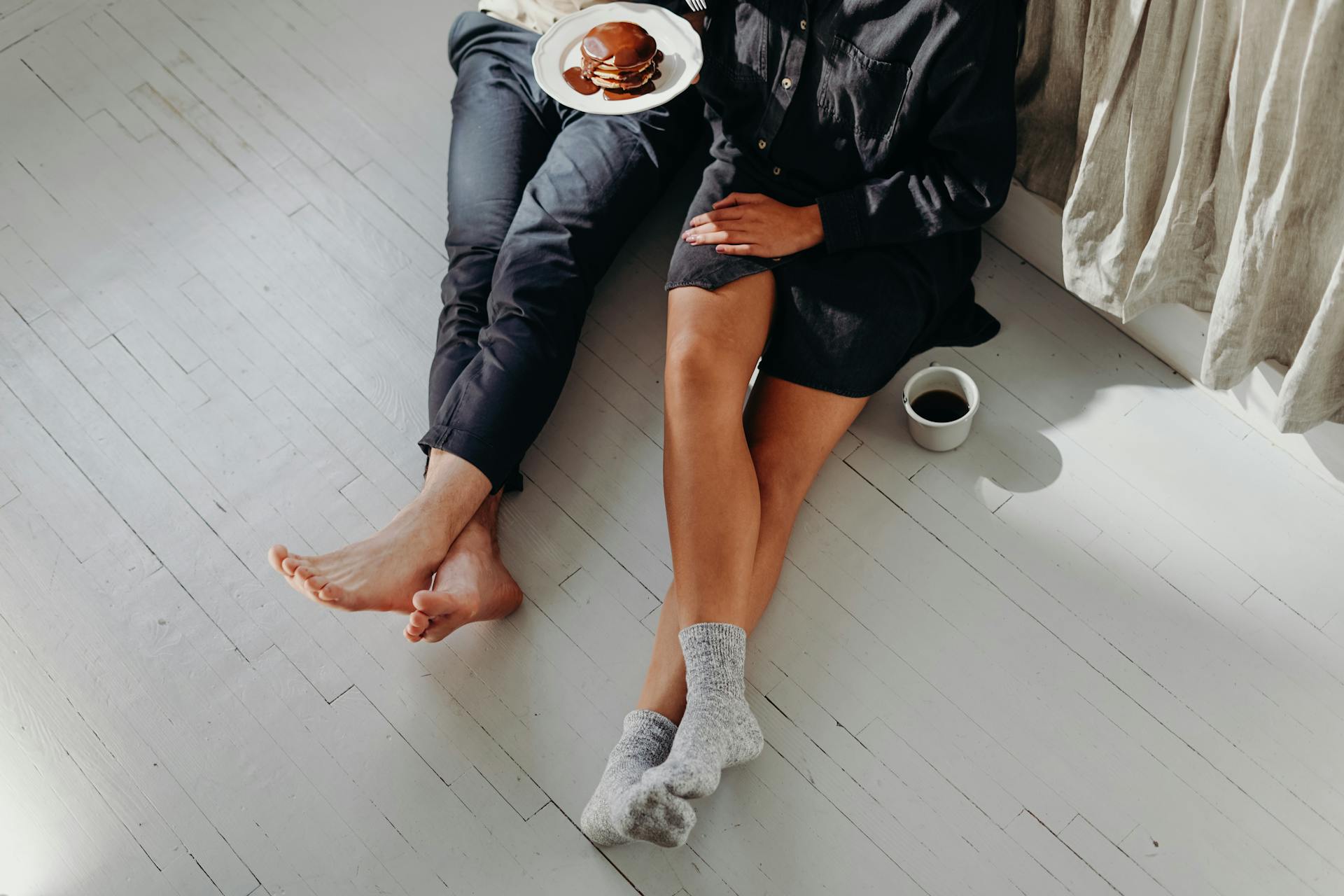 Gros plan d'un couple prenant son petit déjeuner sur le sol | Source : Pexels