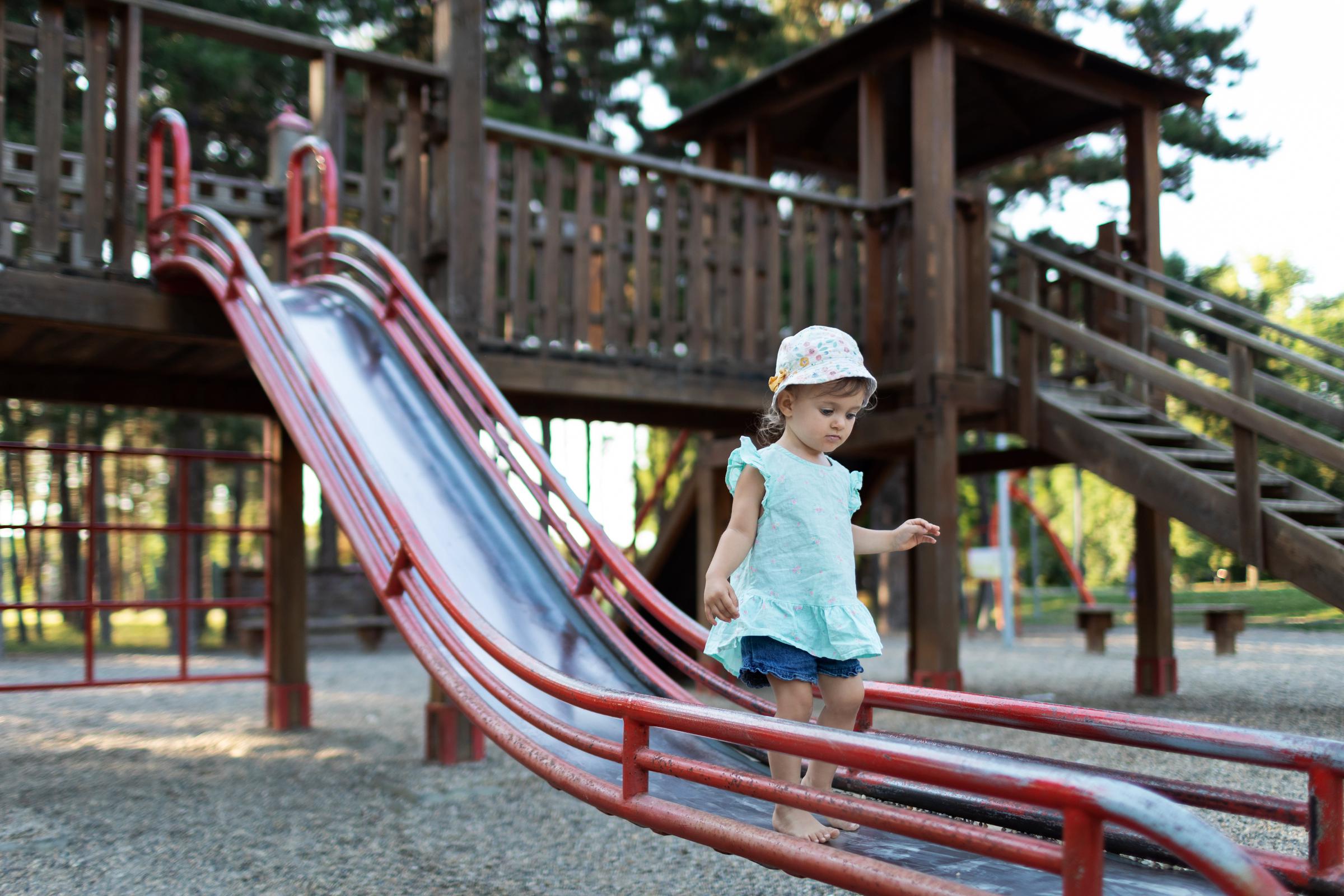 Petite fille jouant sur un toboggan dans un parc I Photo d'illustration I Source : Getty Images