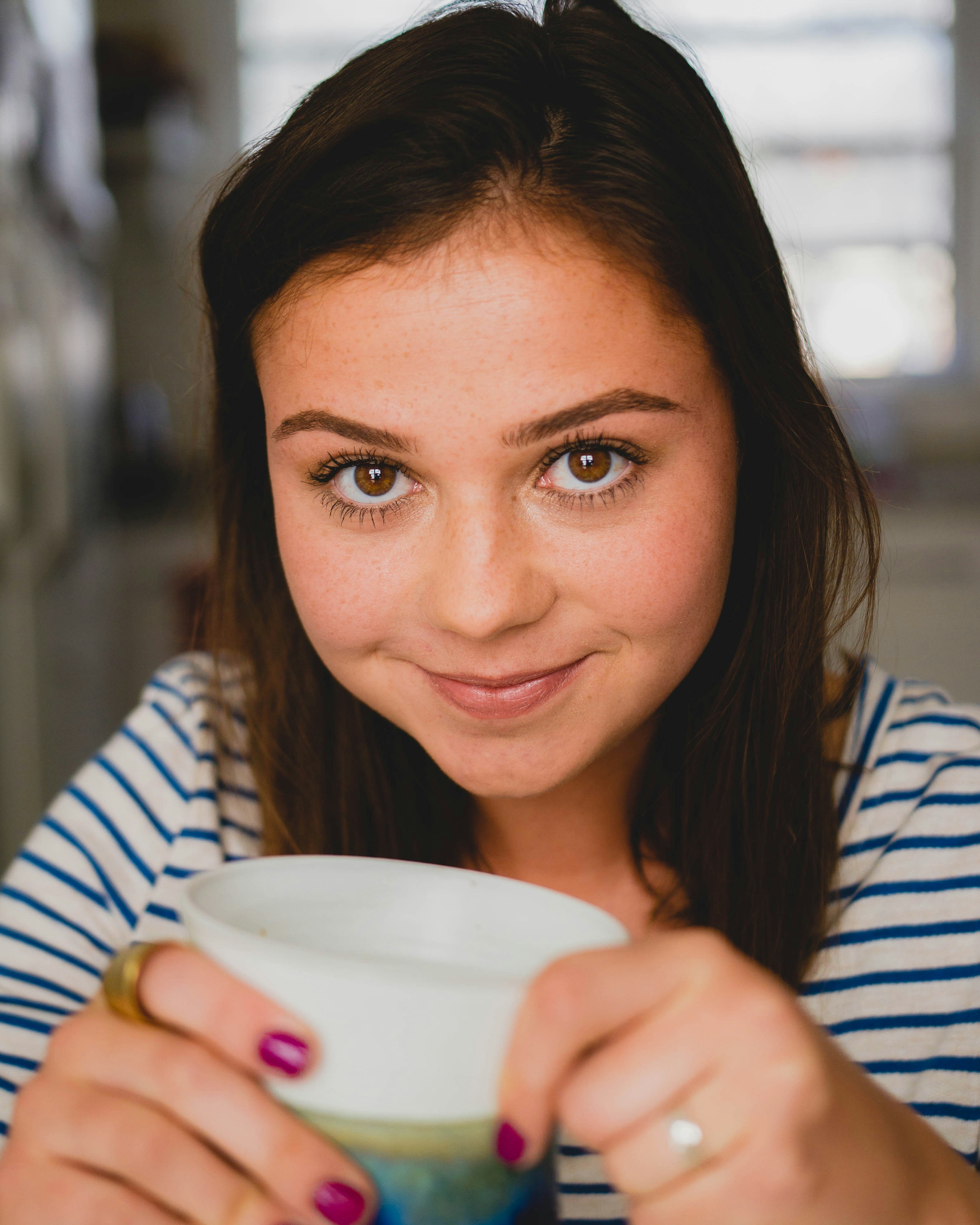 Une fille heureuse tenant une tasse | Source : Unsplash