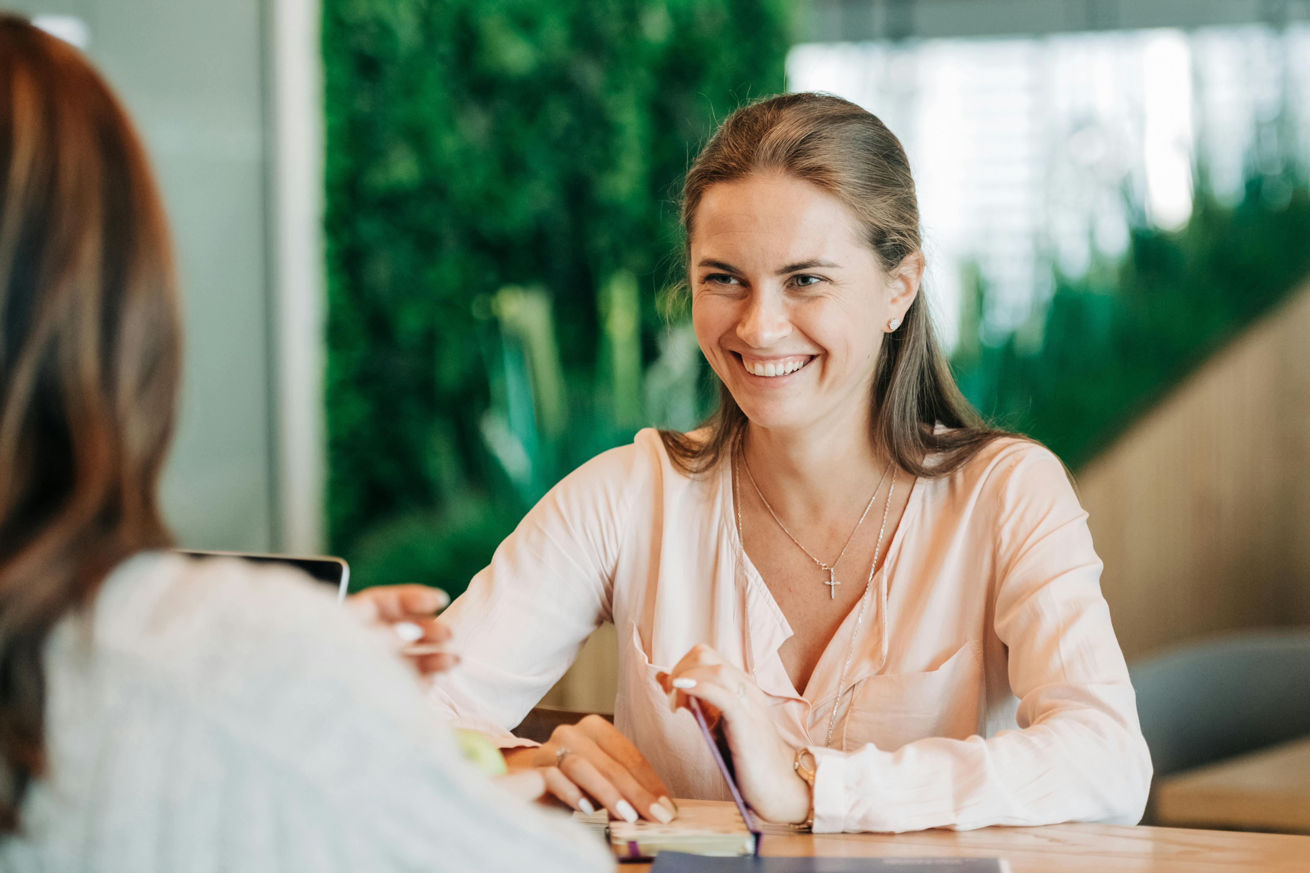Une femme souriante discute avec sa collègue | Source : Pexels
