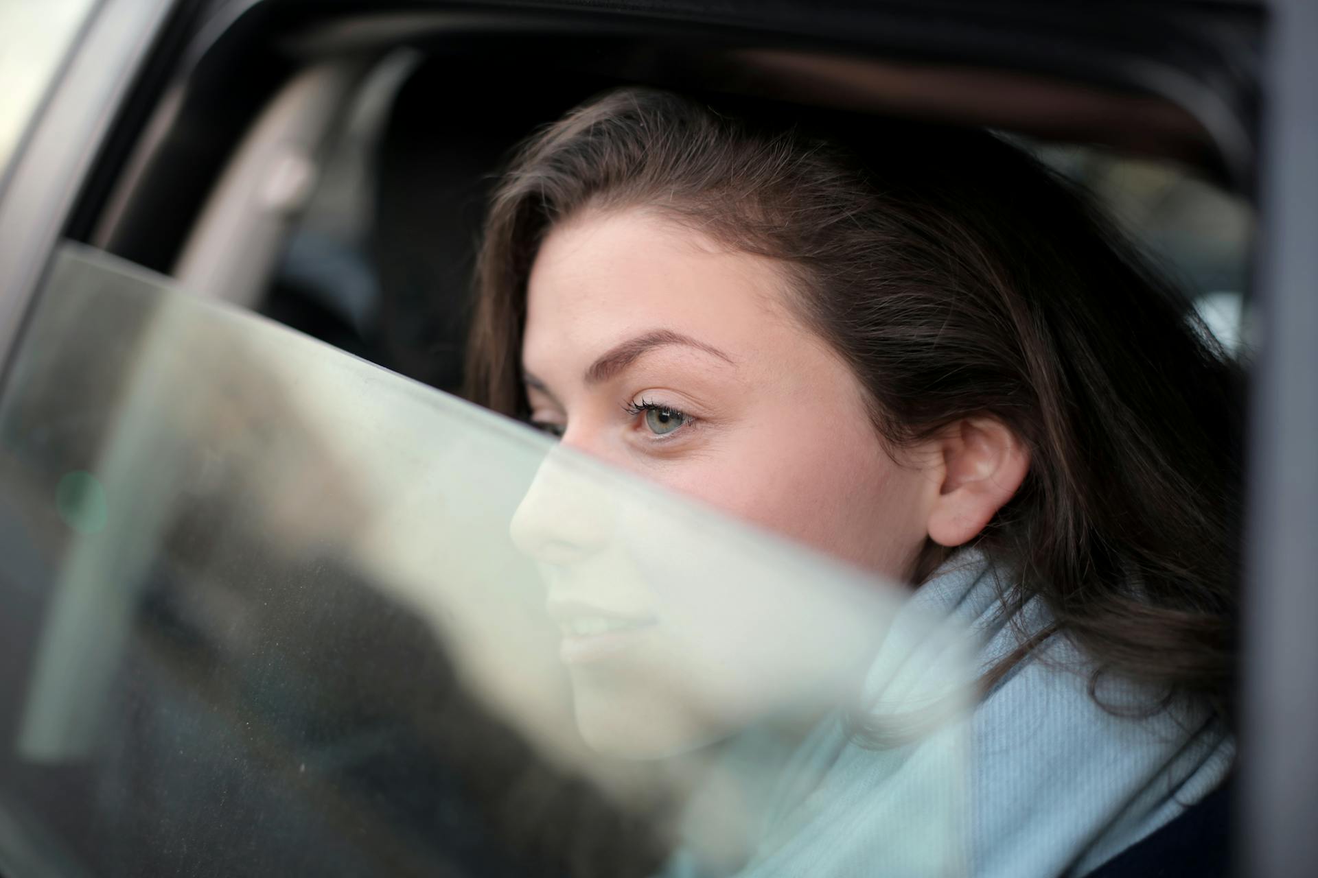 Une femme qui regarde par la fenêtre de la voiture | Source : Pexels