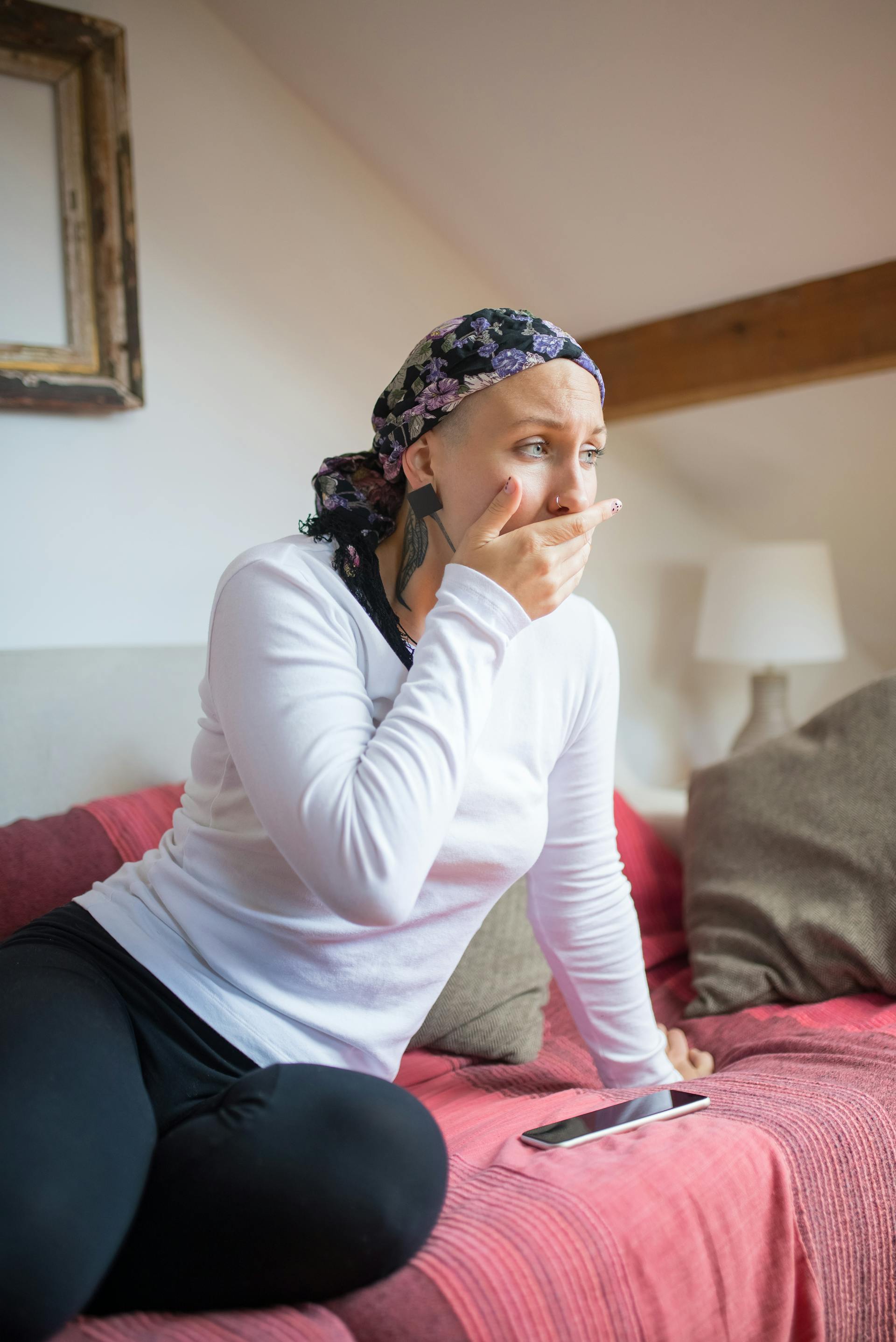 Une femme portant un foulard assise sur un canapé | Source : Pexels