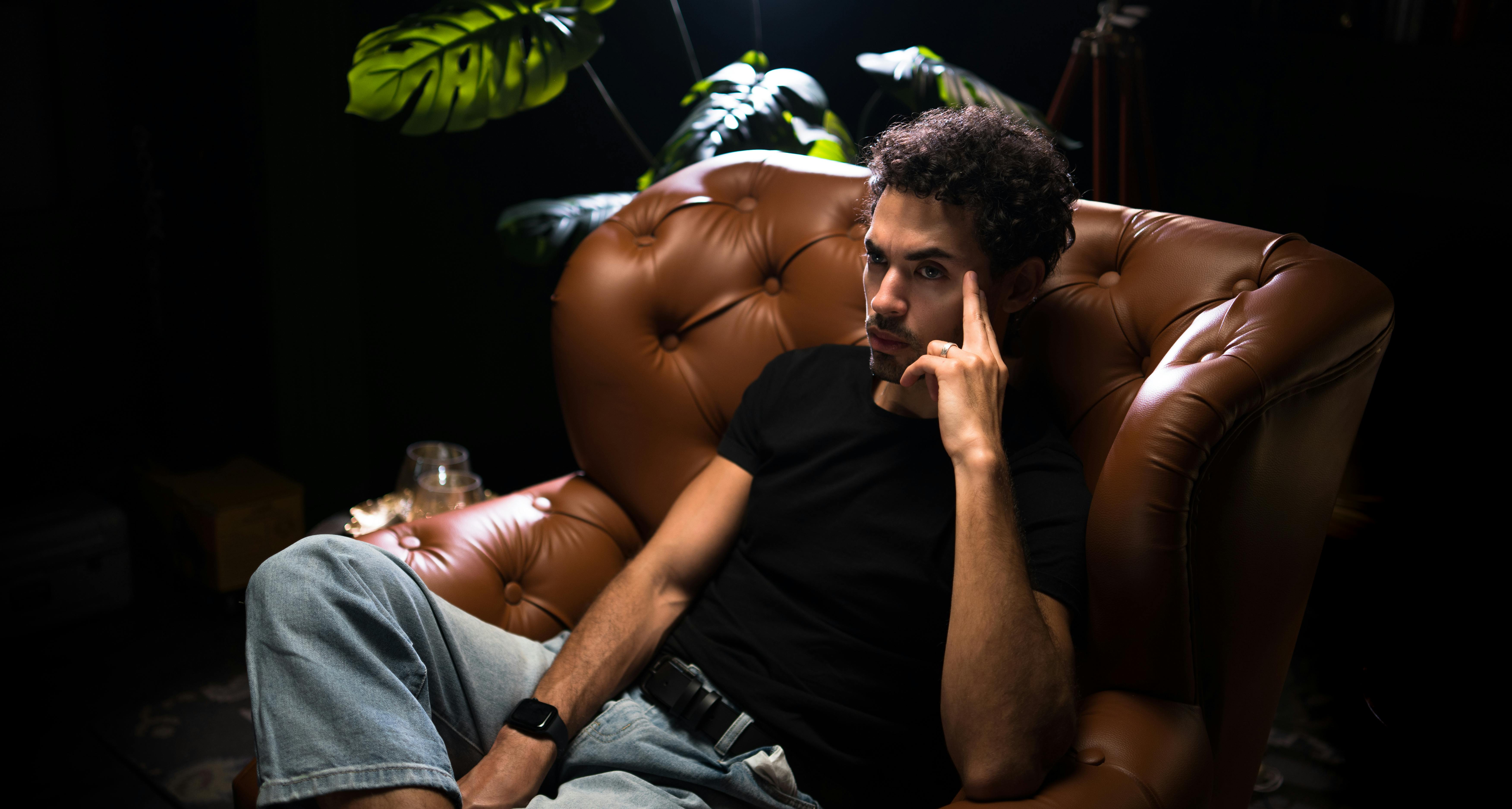 Un homme sérieux assis sur une chaise en cuir | Source : Pexels