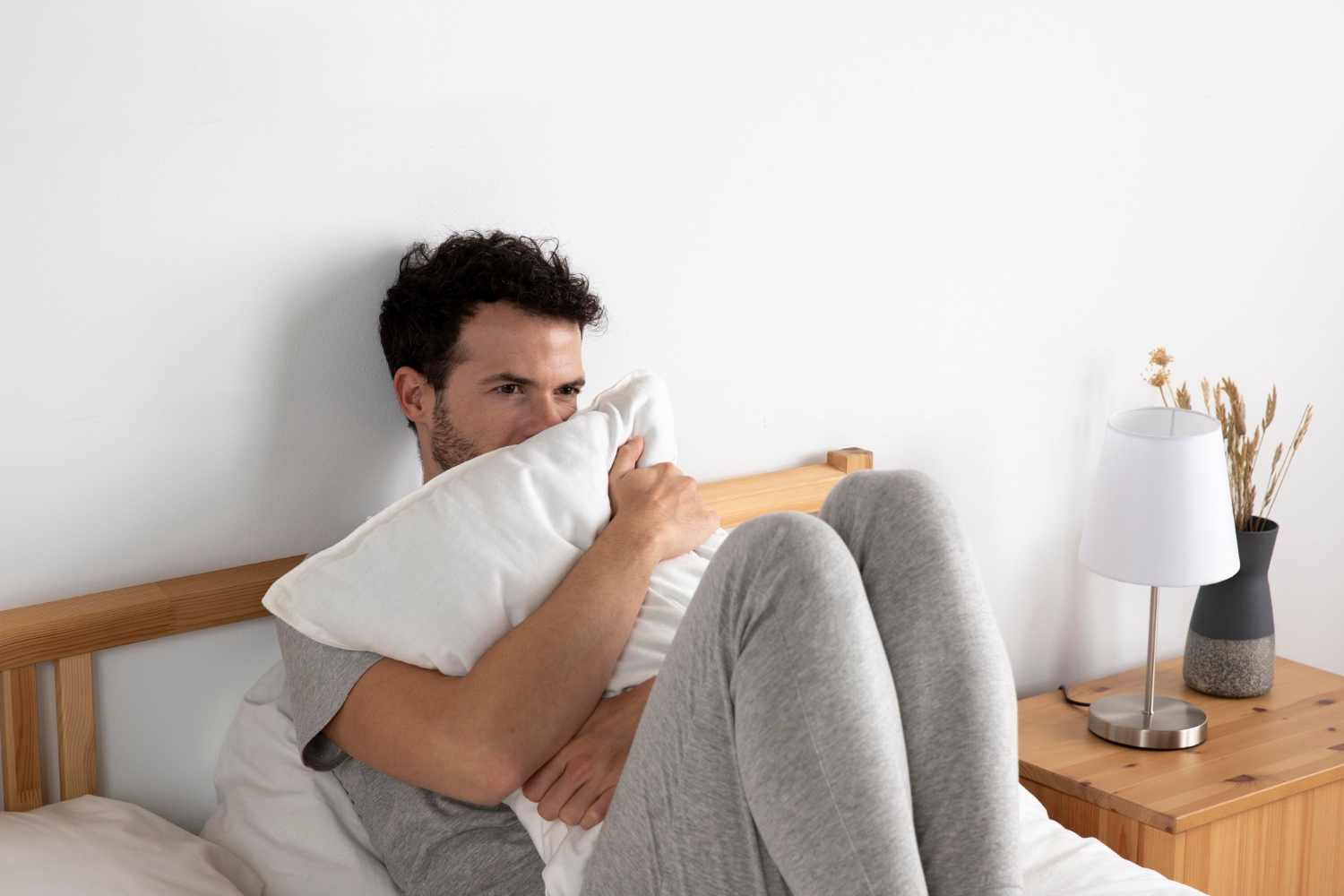Un homme anxieux assis sur le lit | Source : Freepik
