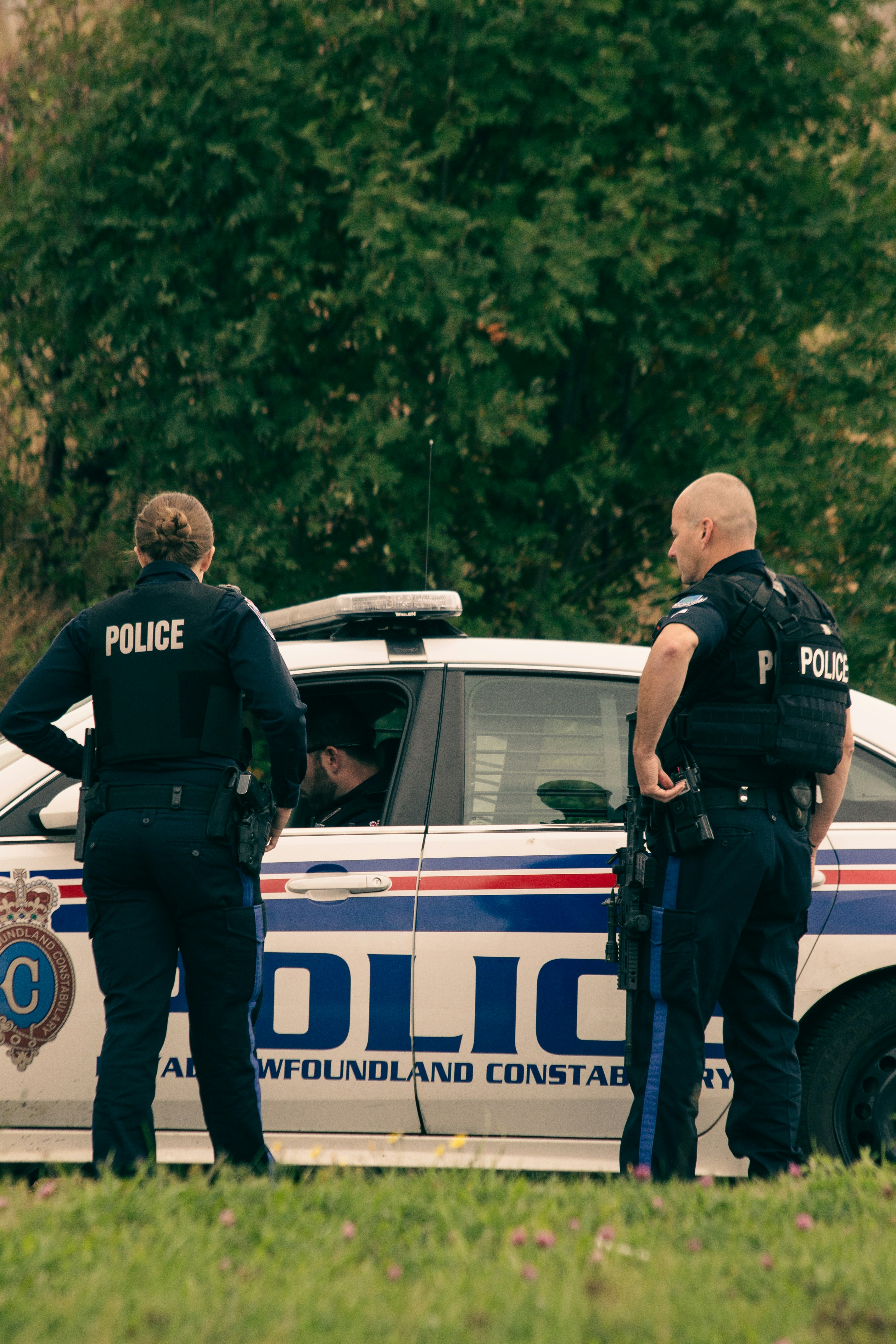 Agents de police debout à l'extérieur d'une voiture de police | Source : Unsplash