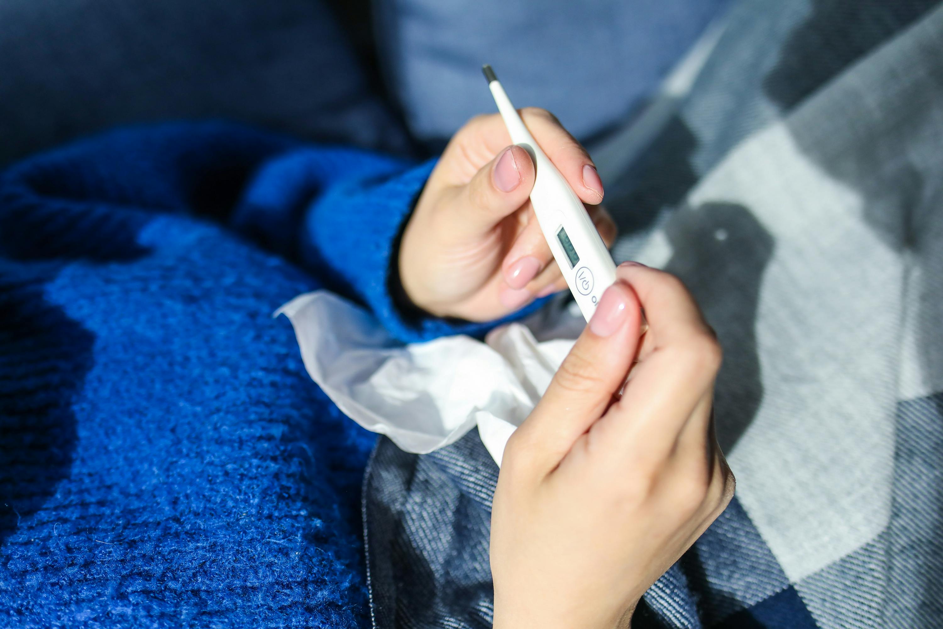 Une femme tenant un thermomètre | Source : Pexels