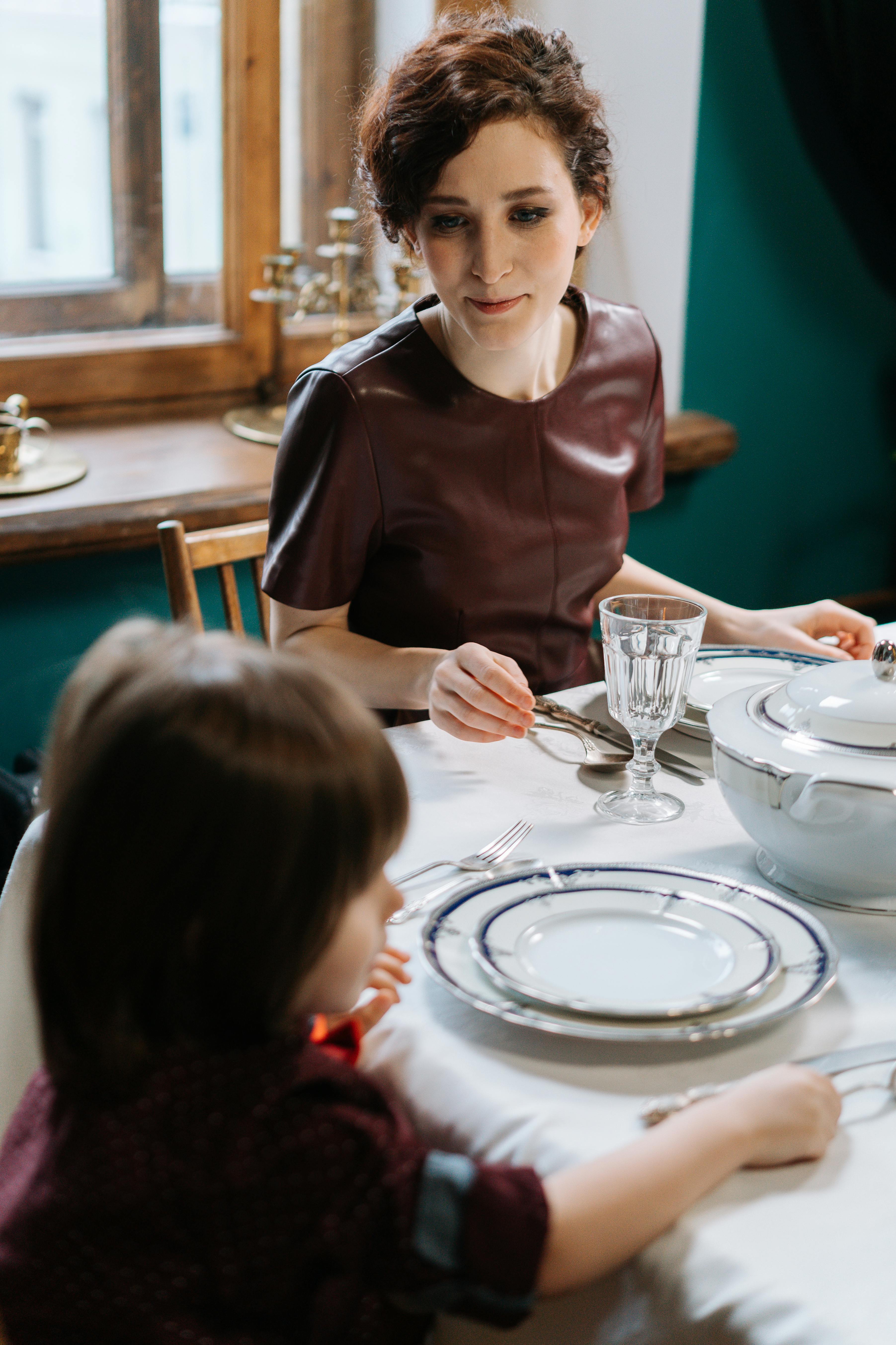 Nounou regardant un garçon assis à côté d'elle | Source : Pexels