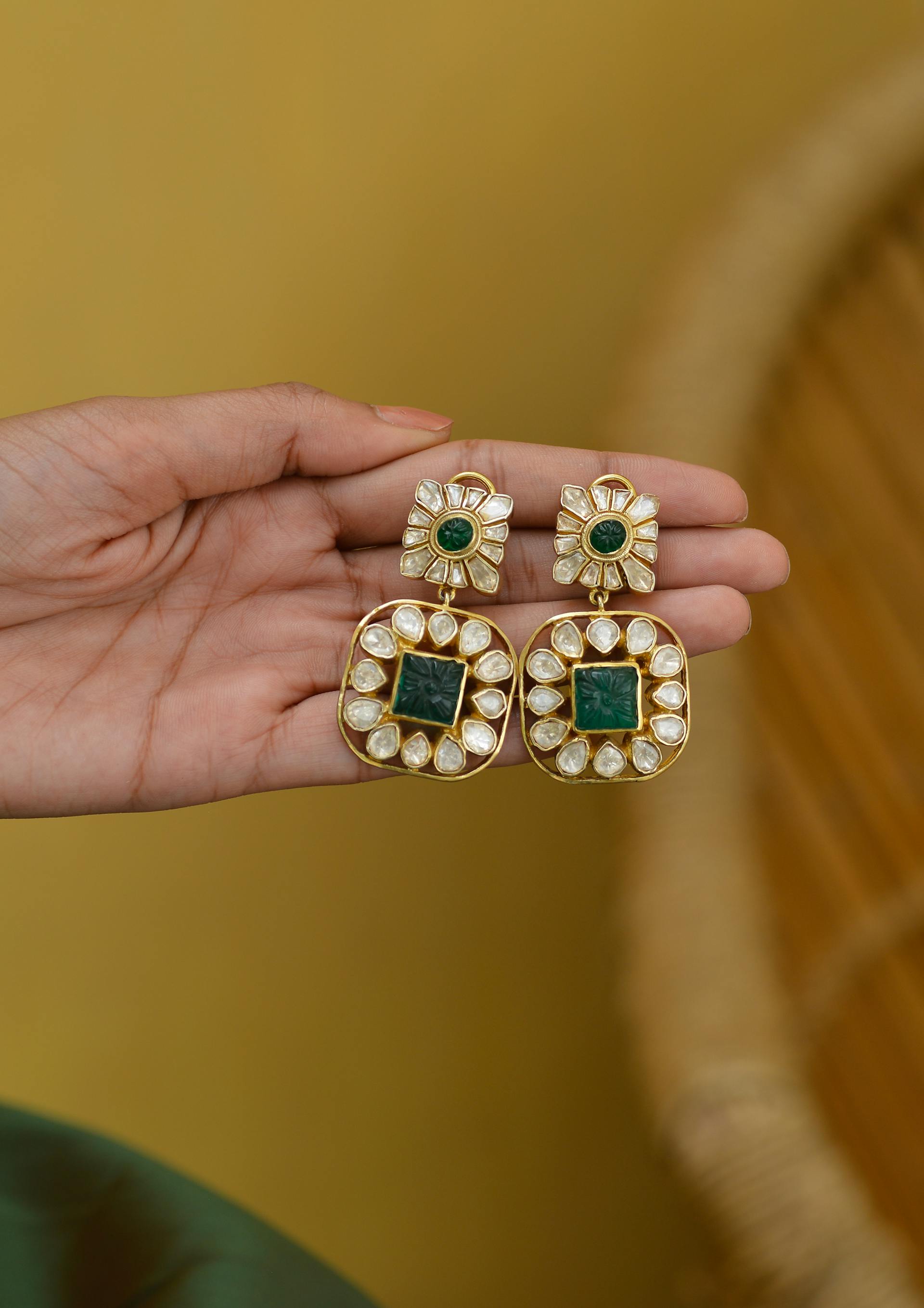 Une personne tenant une paire de boucles d'oreilles | Source : Pexels