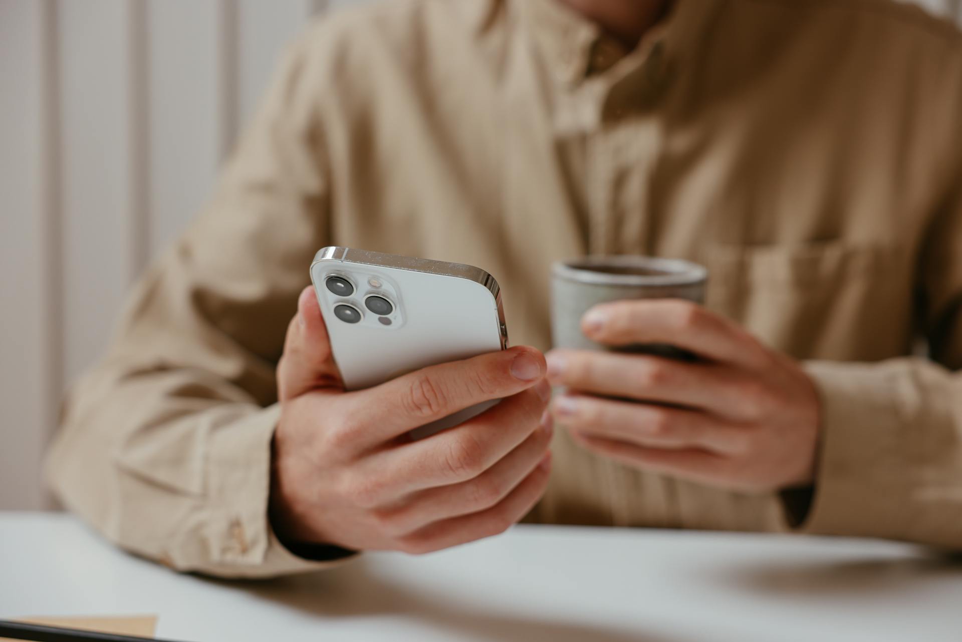 Un homme tenant son téléphone et une tasse | Source : Pexels