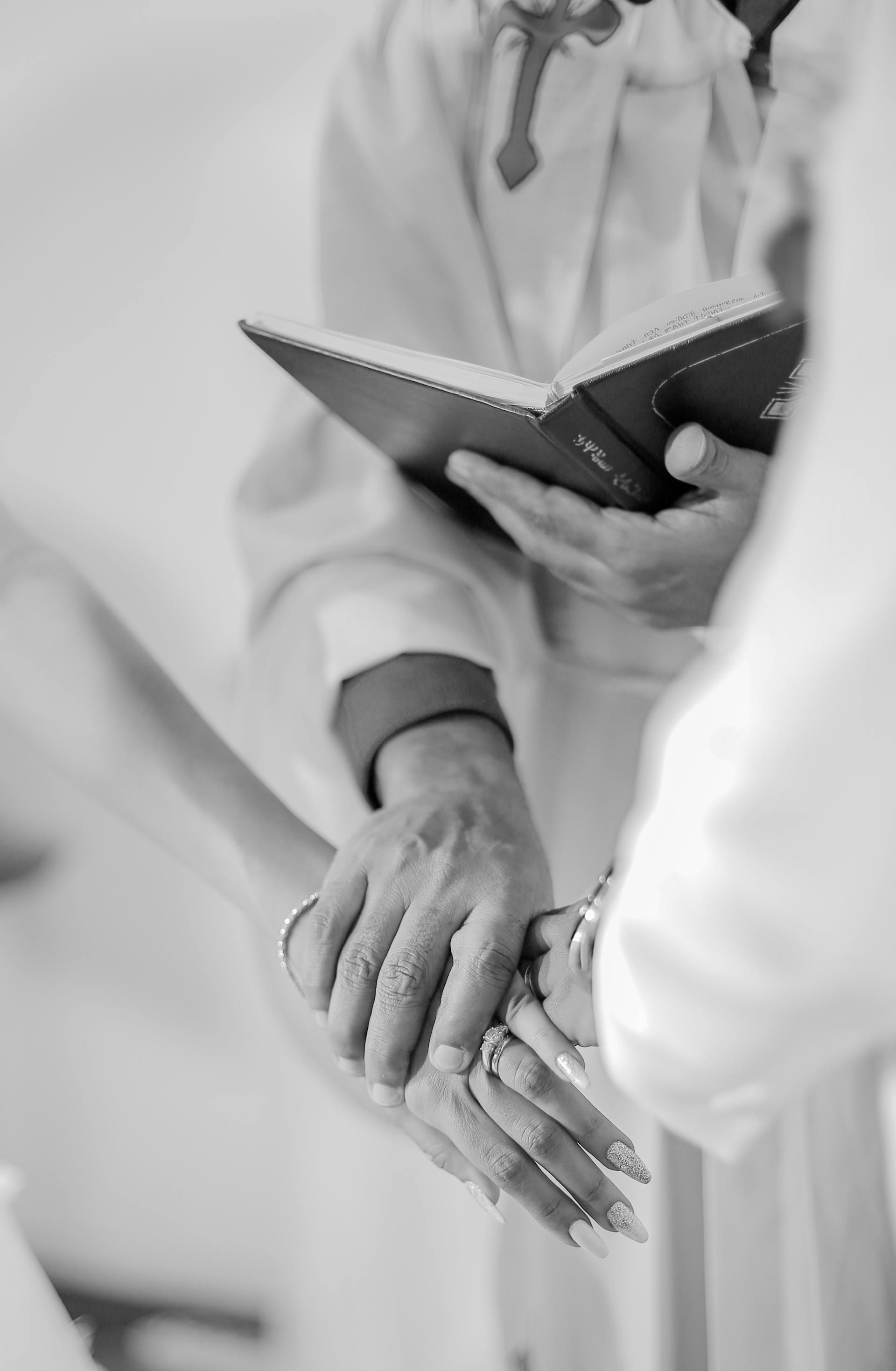 Un prêtre tenant un couple de mariés | Source : Pexels