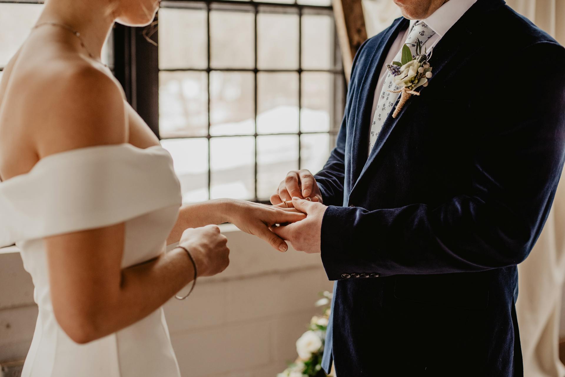 Un marié plaçant une bague au doigt de la mariée | Source : Pexels