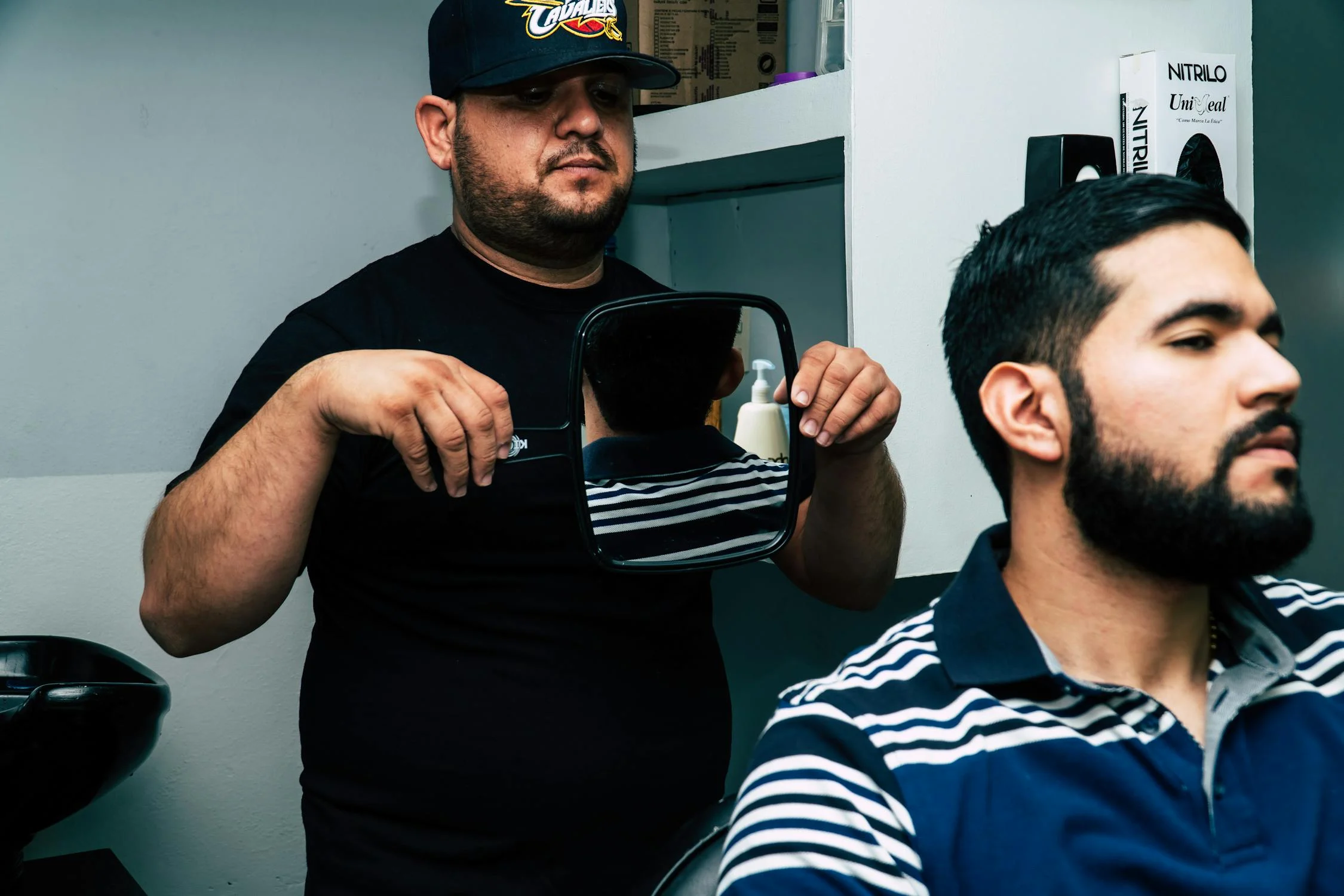 Un barbier tenant un miroir | Source : Pexels
