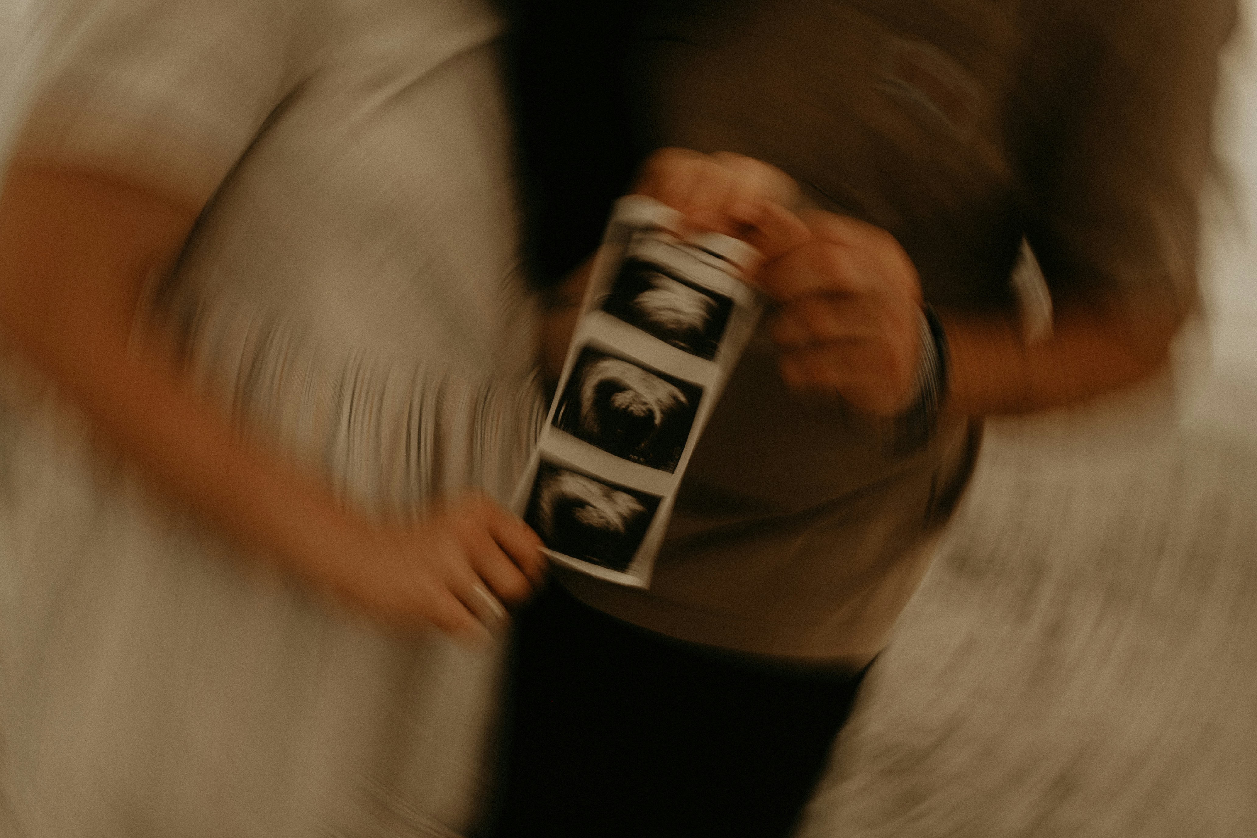 Un couple tenant des images d'échographie | Source : Unsplash