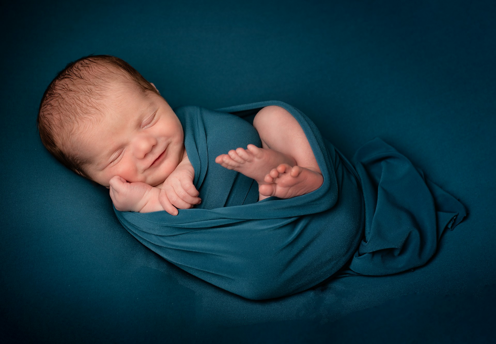 Un adorable bébé enveloppé dans une couverture bleue | Source : Unsplash