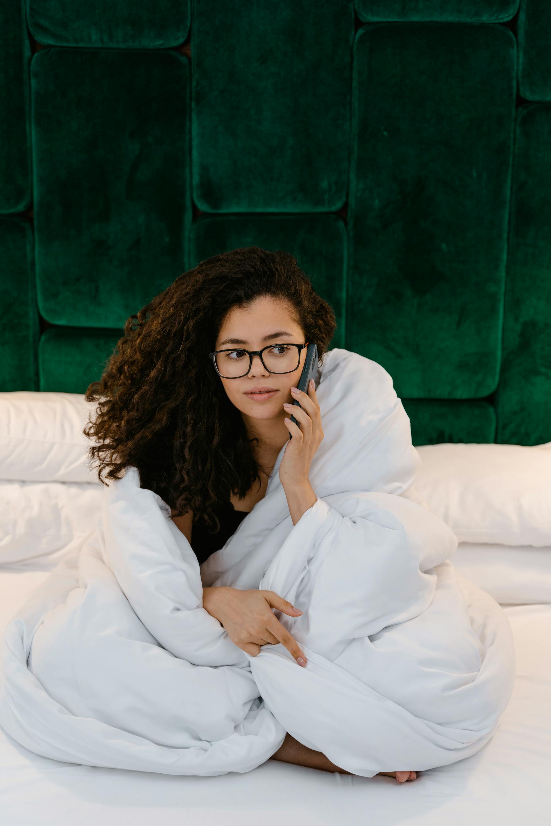 Une femme qui parle au téléphone dans son lit | Source : Pexels