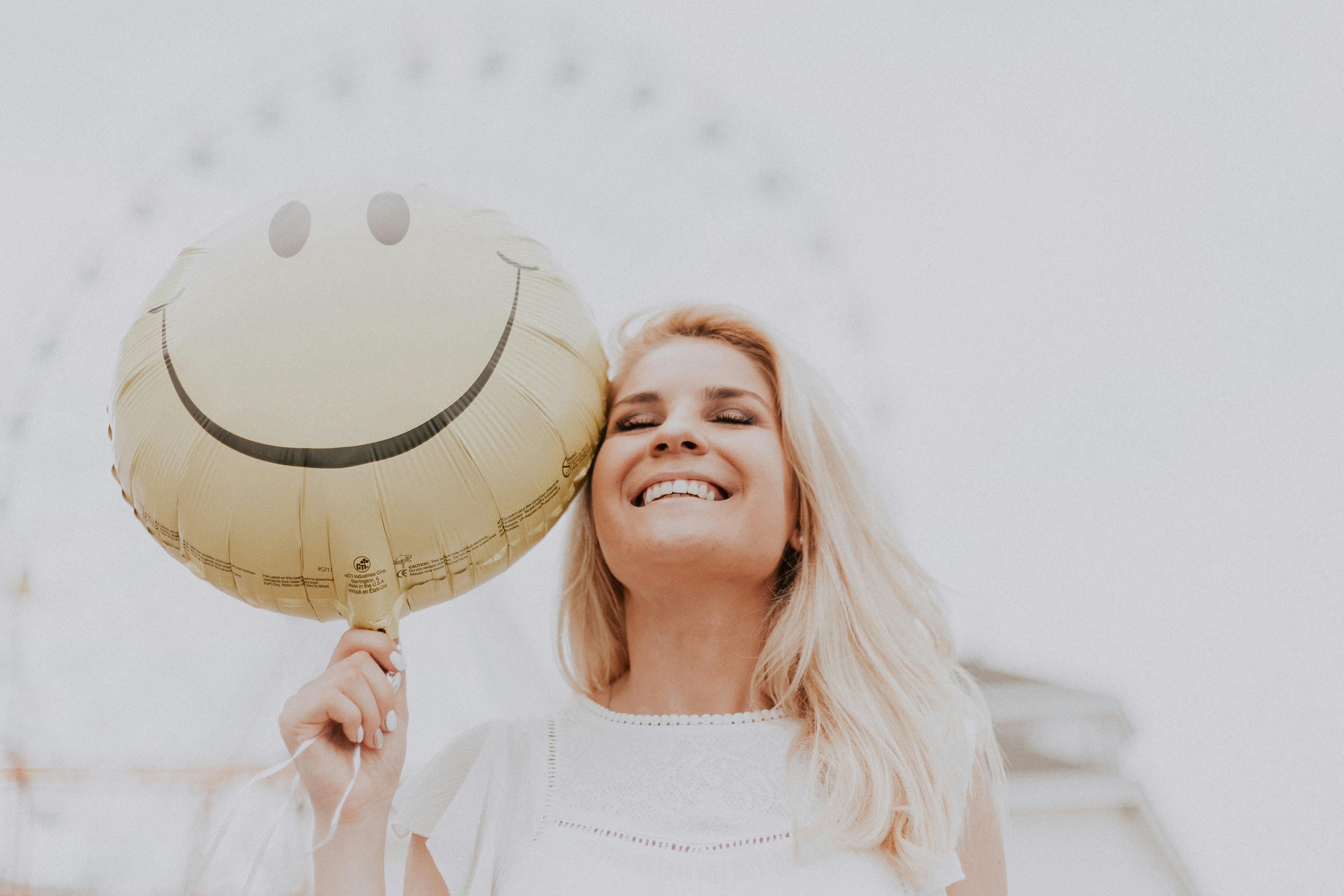 Une femme souriante tenant un ballon | Source : Pexels