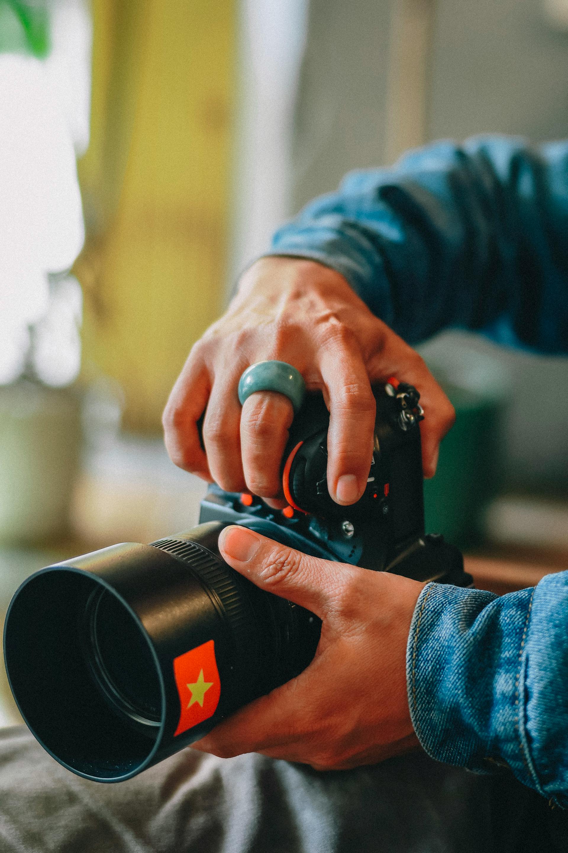 Un photographe en train d'ajuster l'objectif de son appareil photo | Source : Pexels