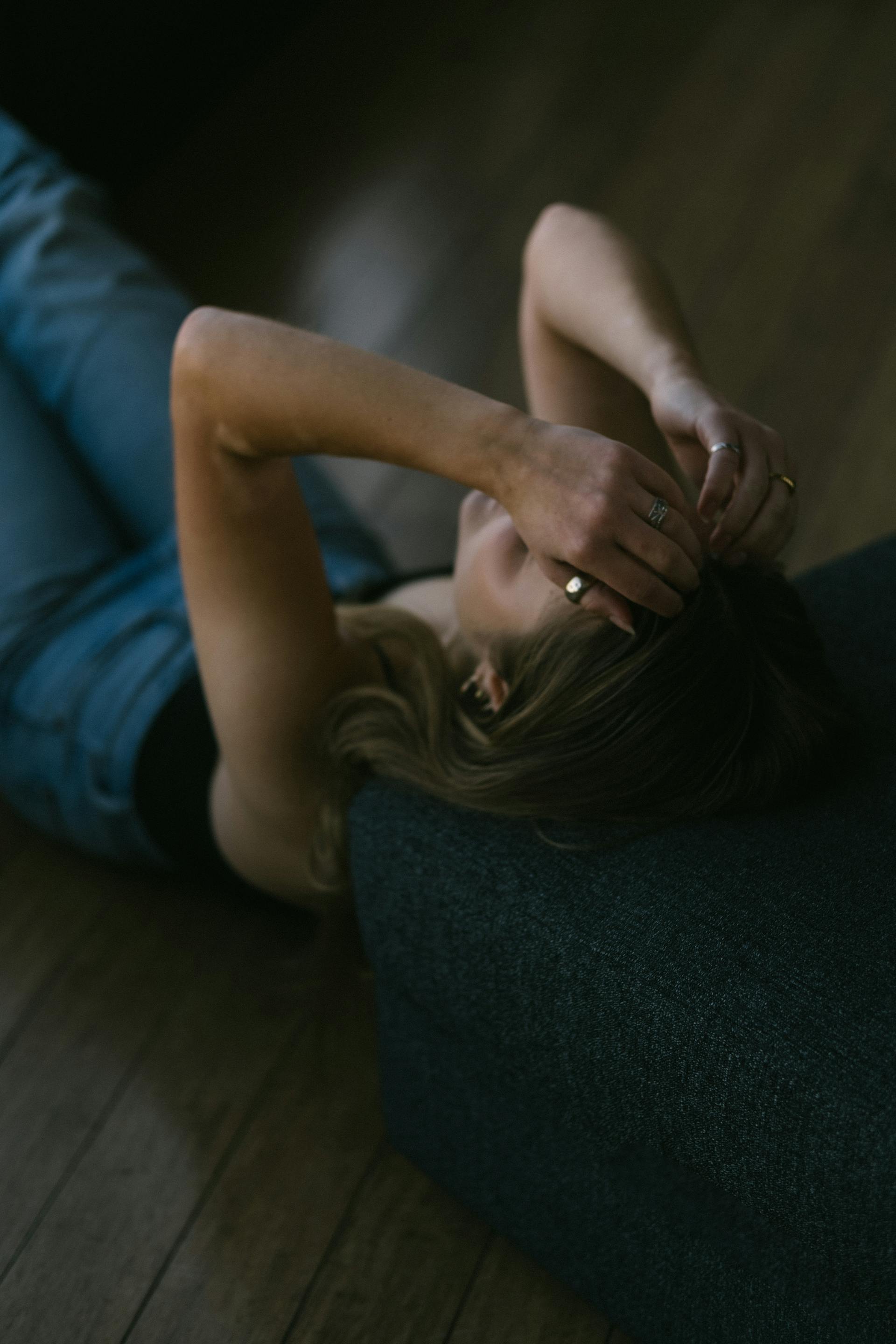 Une femme allongée sur le sol, les mains sur la tête | Source : Pexels