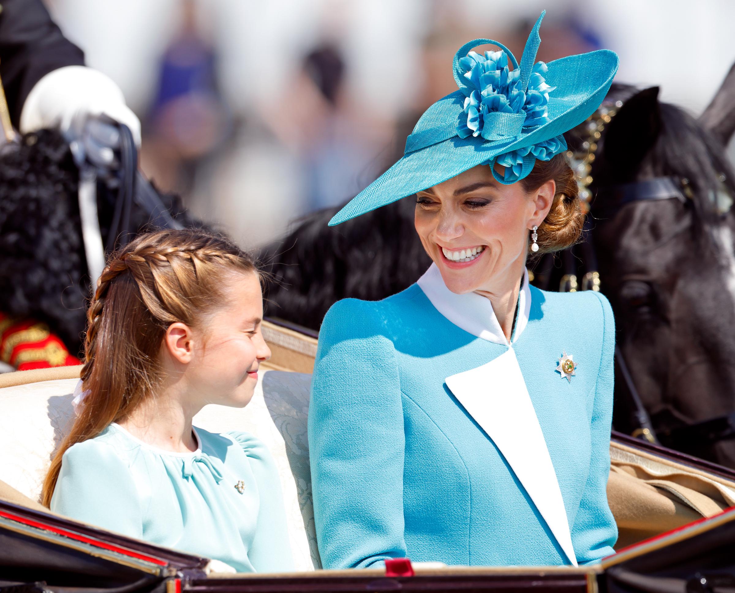 La princesse Charlotte de Galles et Catherine, princesse de Galles, se sourient l'une à l'autre alors qu'elles quittent le palais de Buckingham dans une calèche lors du défilé du Trooping The Colour 2025.