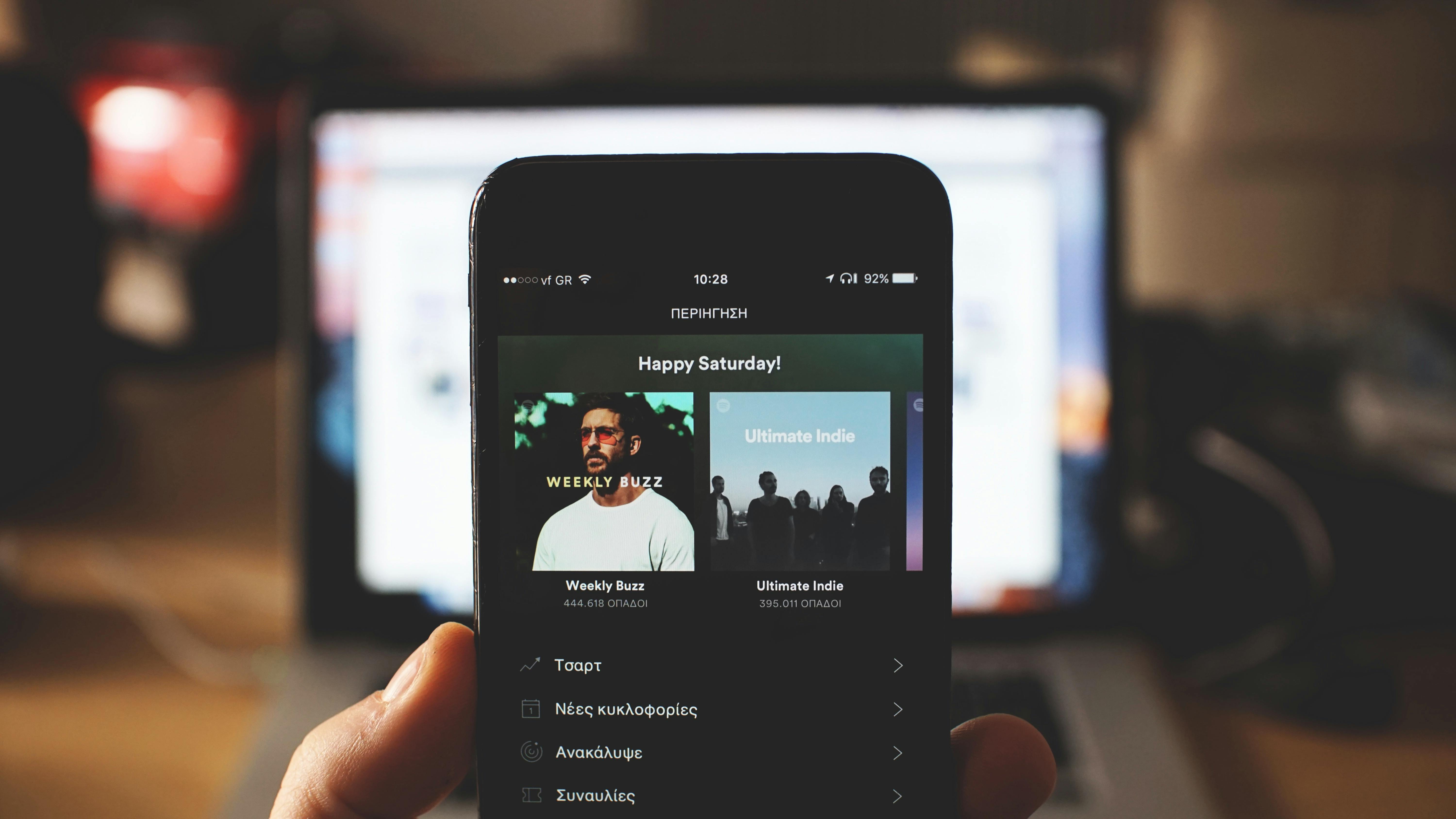 Une personne tenant un téléphone ouvert sur Spotify | Source : Pexels