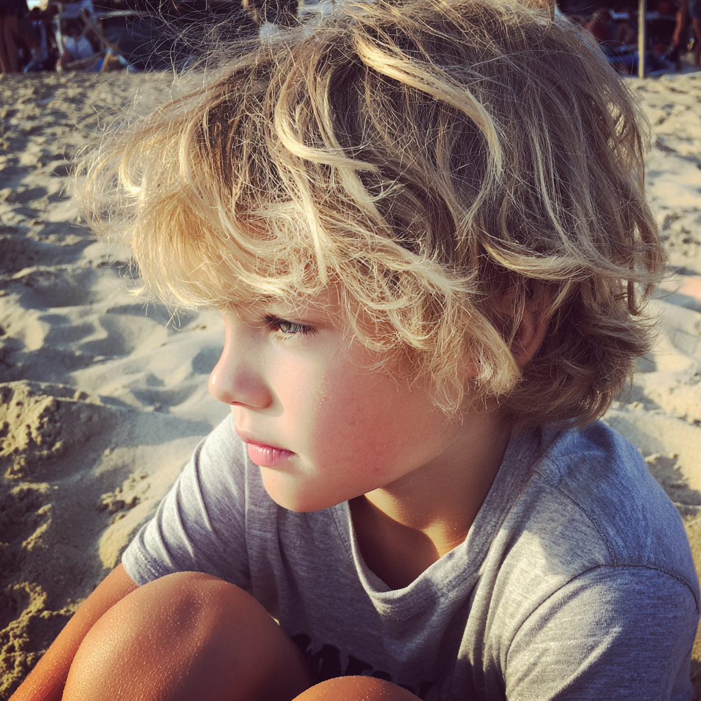 Un petit garçon assis à la plage | Source : Midjourney