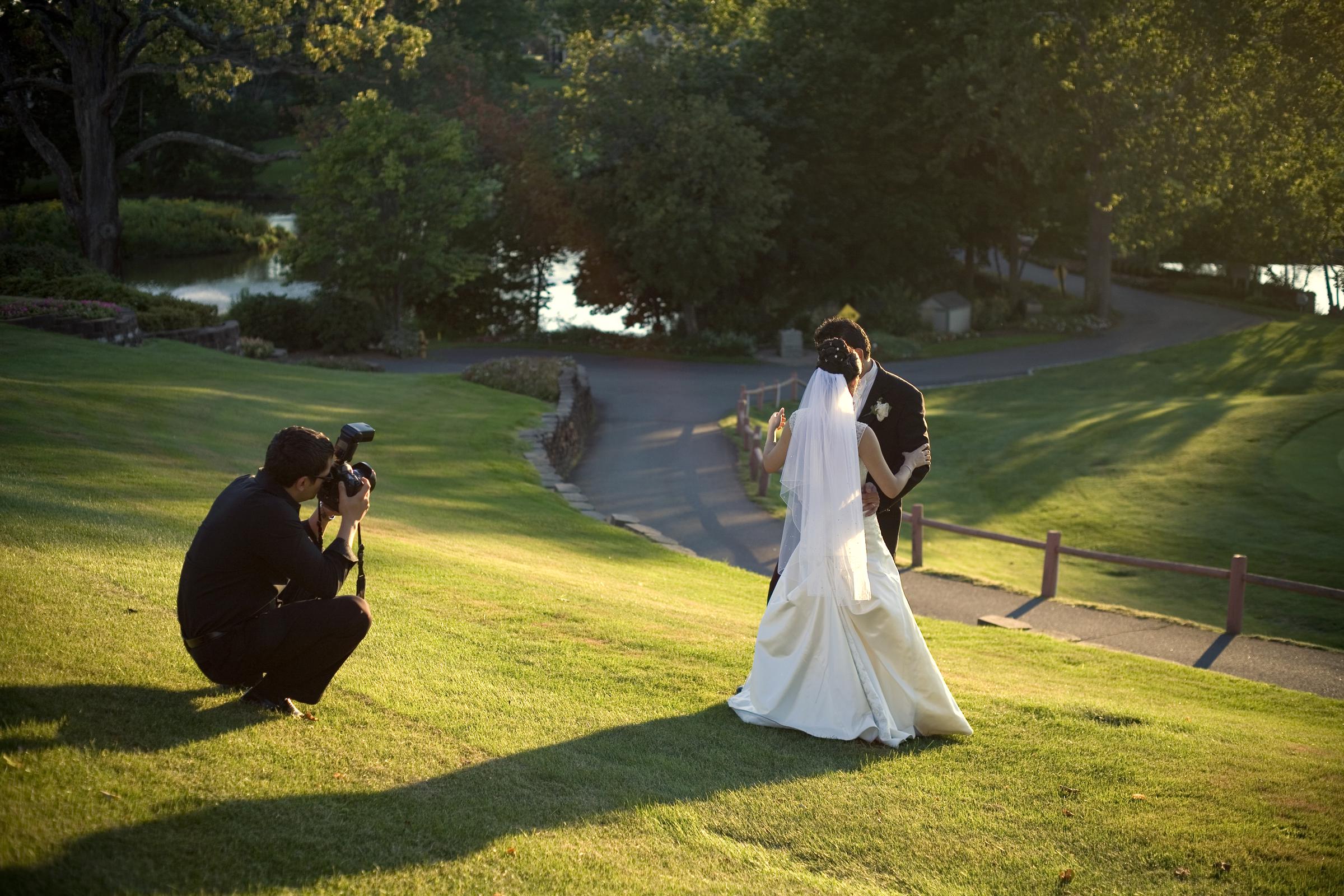 Photographe essayant de photographier un couple de mariés en plein air. Photo d'illustration I Source : Getty Images
