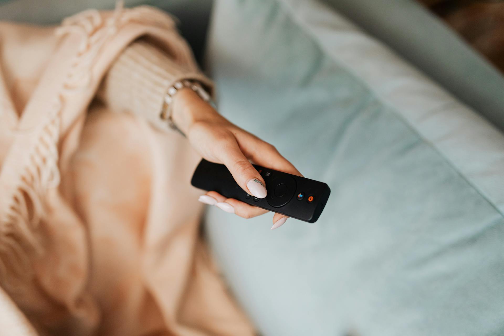 Gros plan d'une femme tenant une télécommande | Source : Pexels