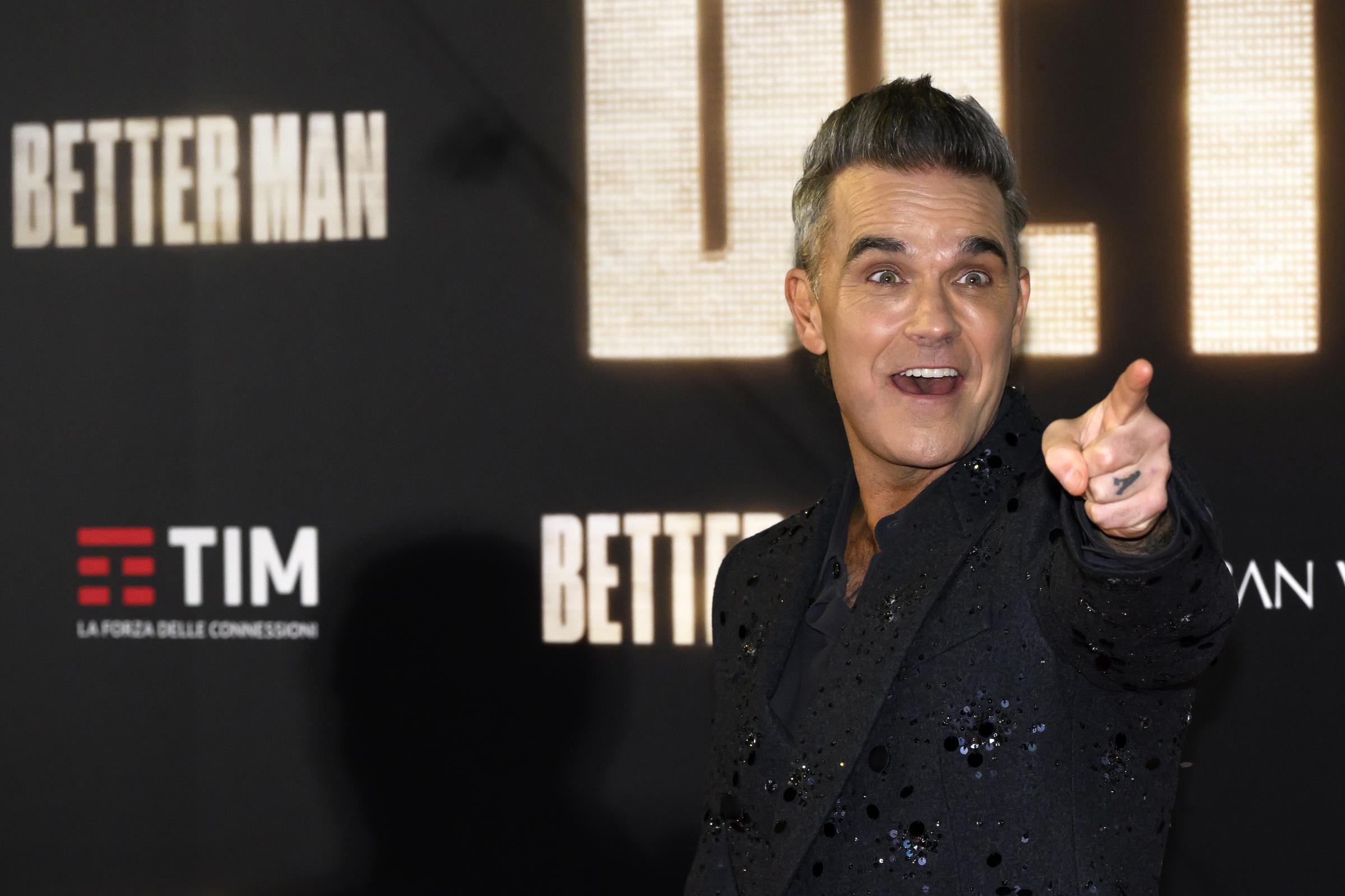 Robbie Williams sur le tapis rouge pour le film « Better Man » le 6 décembre 2024 à Rome, en Italie. Arborant un sourire espiègle et pointant les caméras, il a illuminé la première dans un costume scintillant à la hauteur du prestige de l'événement.