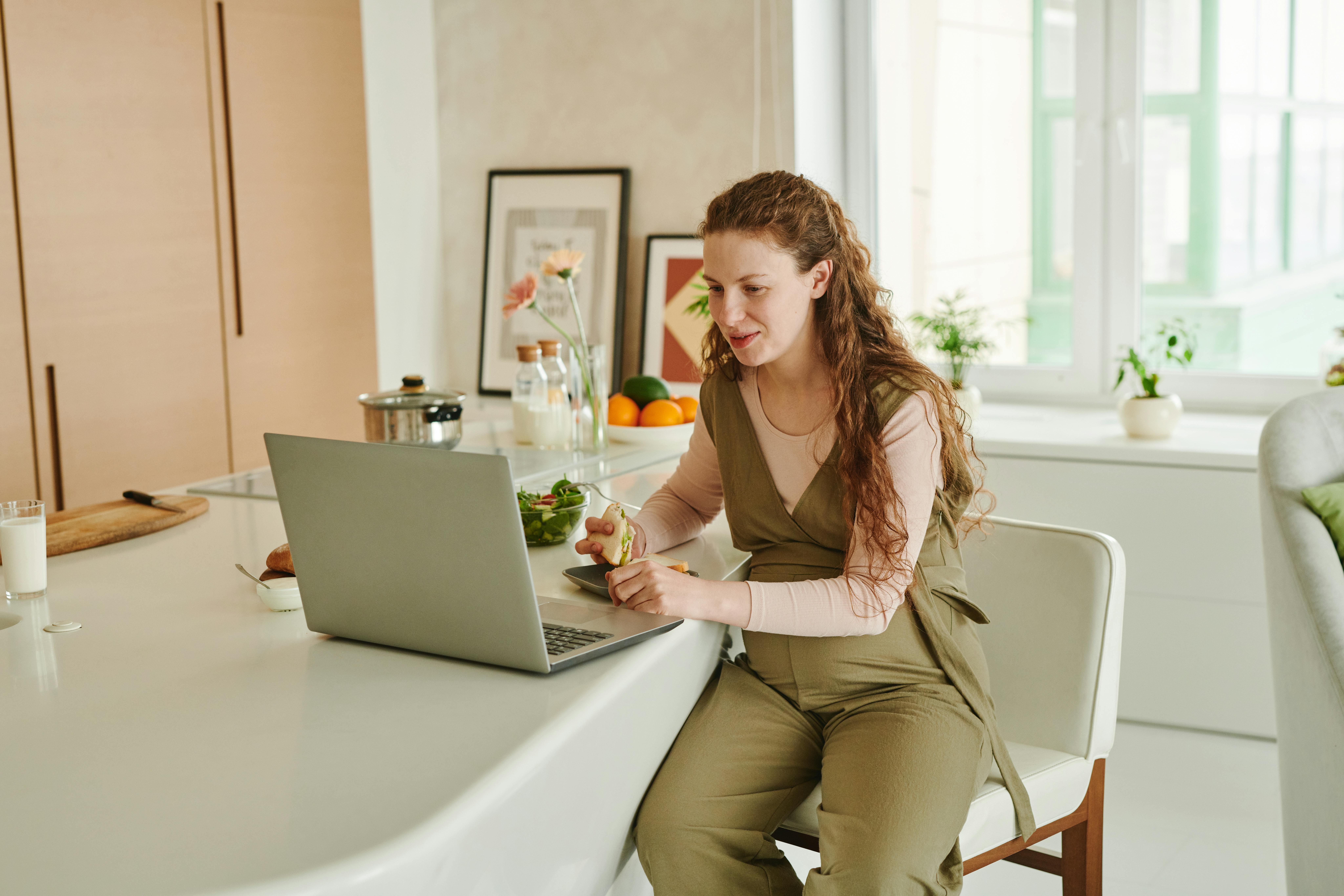 Une femme assise sur une chaise et utilisant un ordinateur portable | Source : Pexels